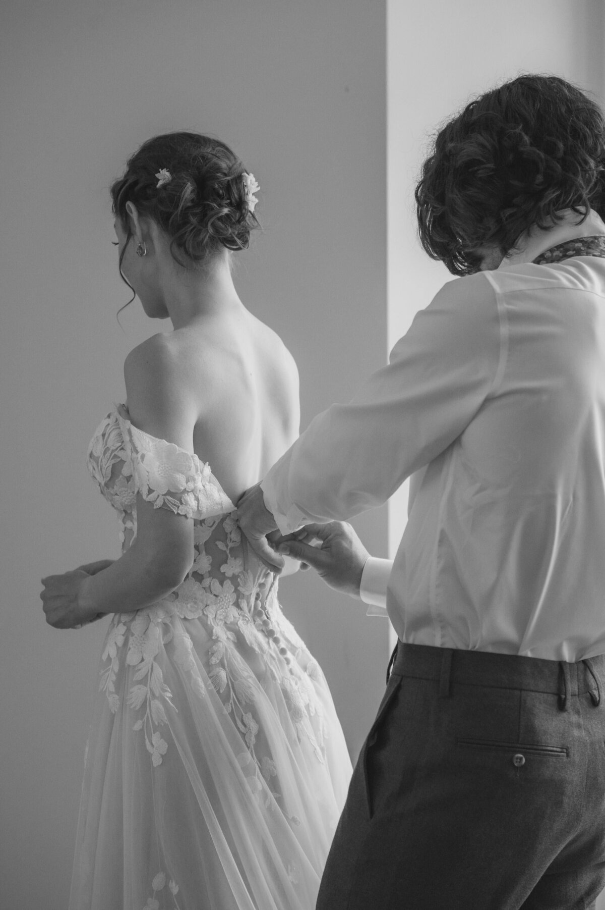 Newlyweds help one another get ready for their wedding