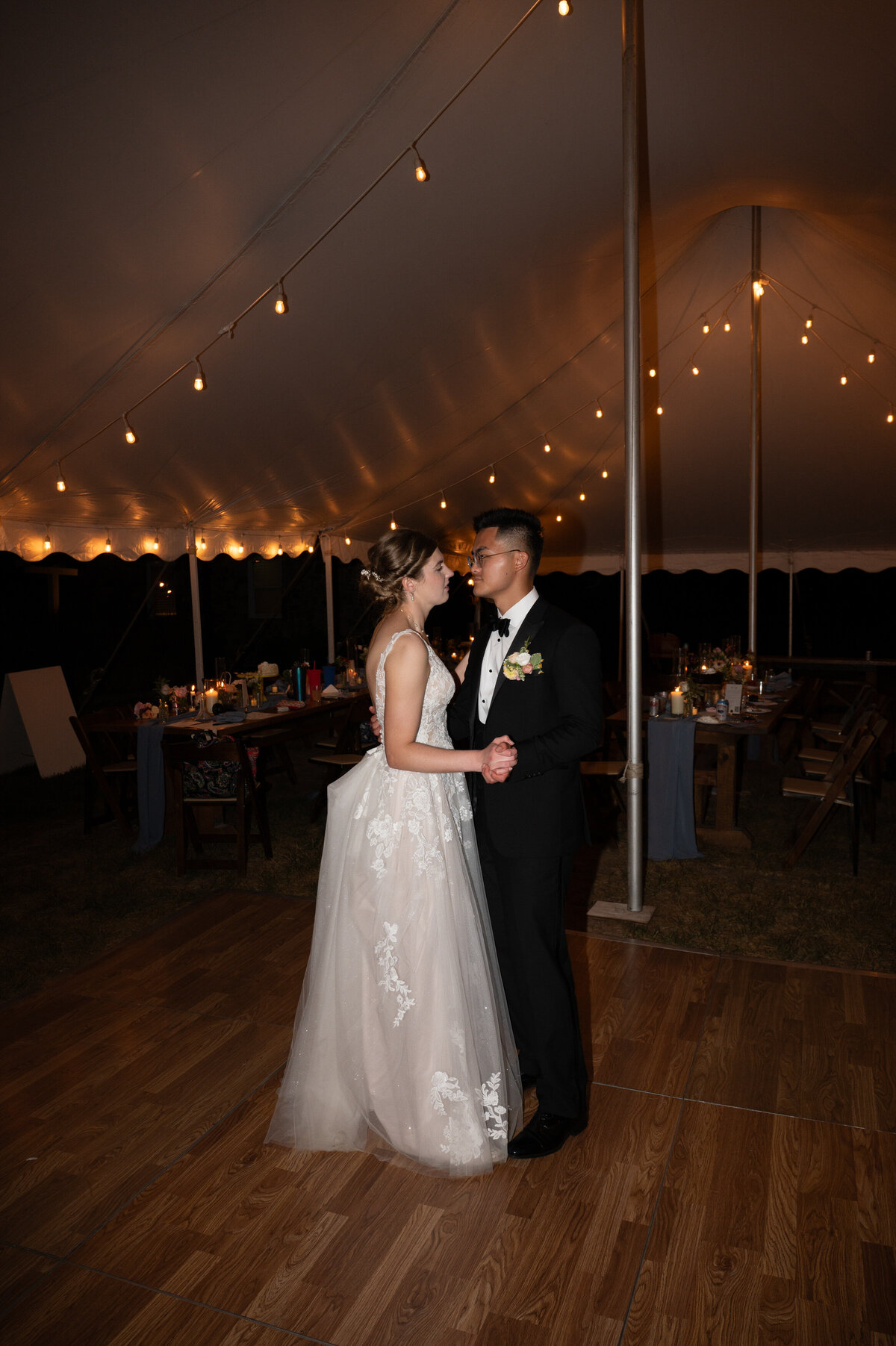 A bride and groom dancing along on a small dance floor