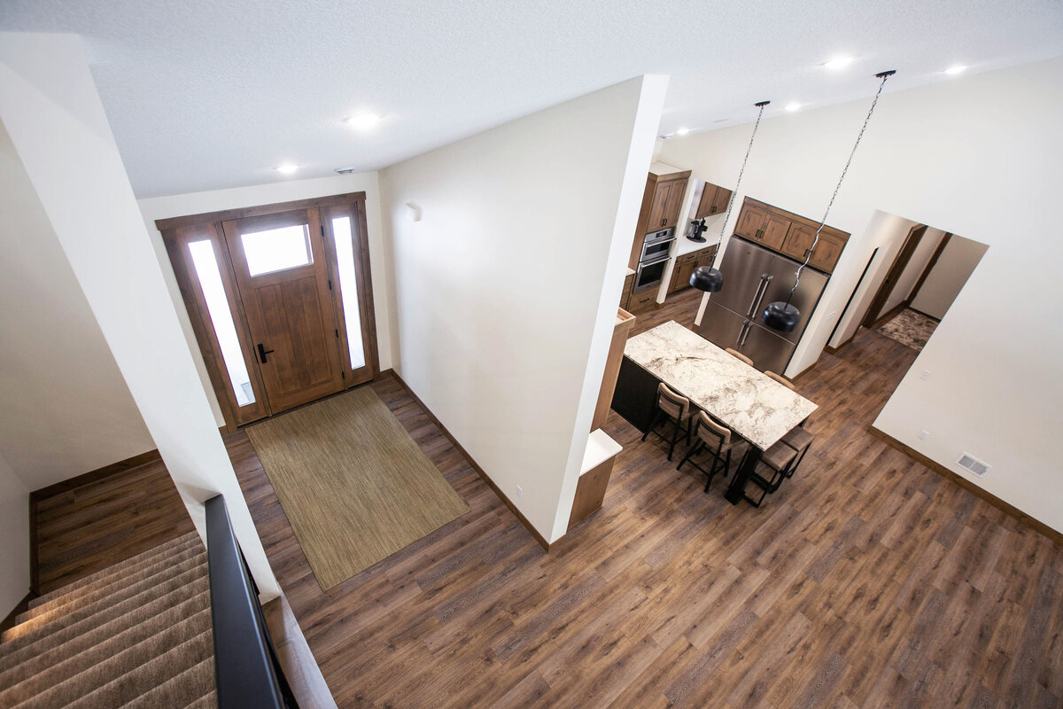 Light-filled entryway with wood flooring and neutral tones in a custom-built Elk River home