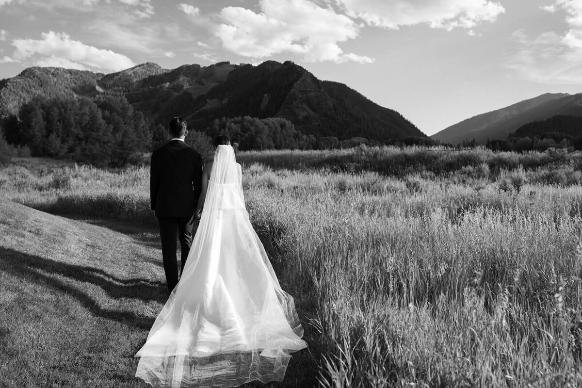 Black-and-white portrait of newlyweds at Aspen Meadows Resort, capturing a romantic moment with stunning mountain views and the bride's sweeping veil.