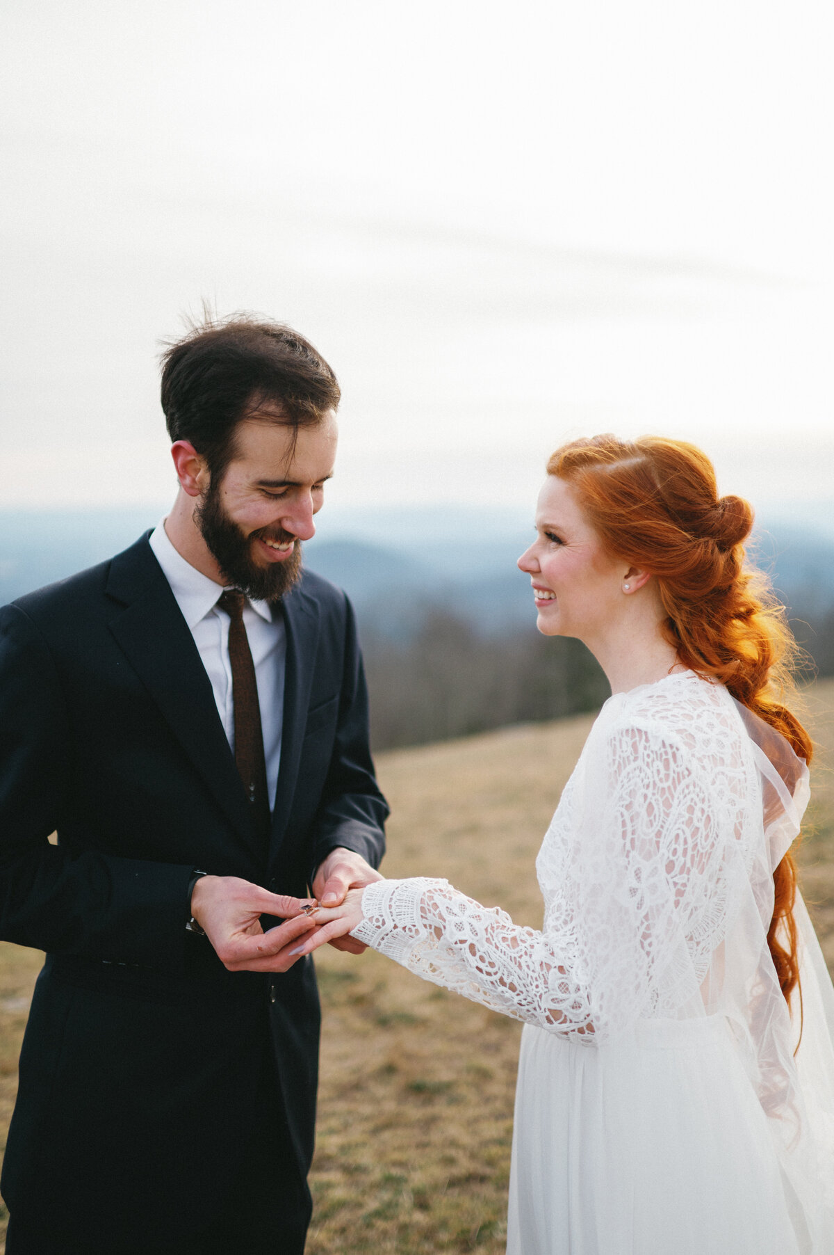 bride and groom exchange rings in asheville mountains