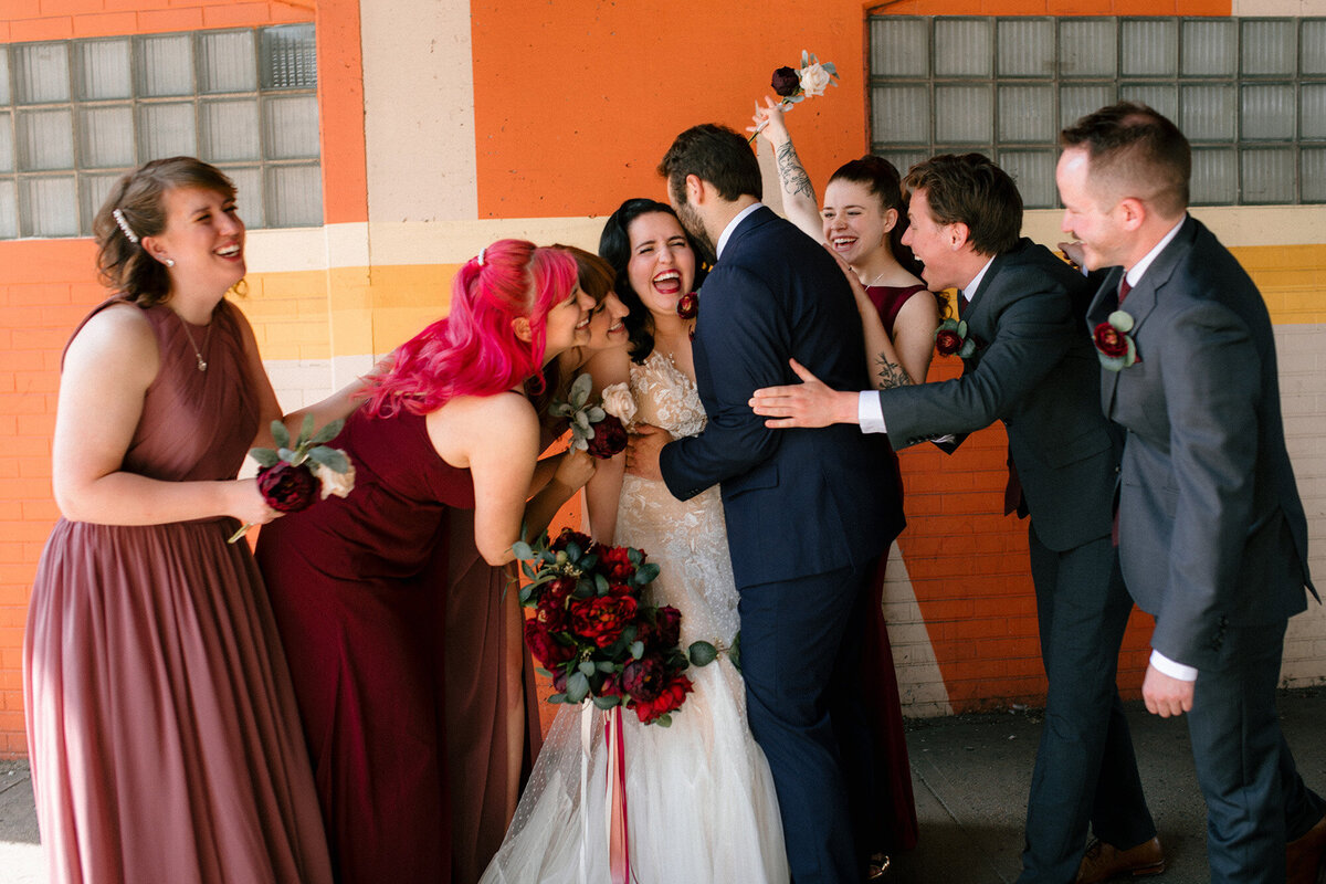 bride-and-groom-embraced-by-bridal-party-and-groomsmen