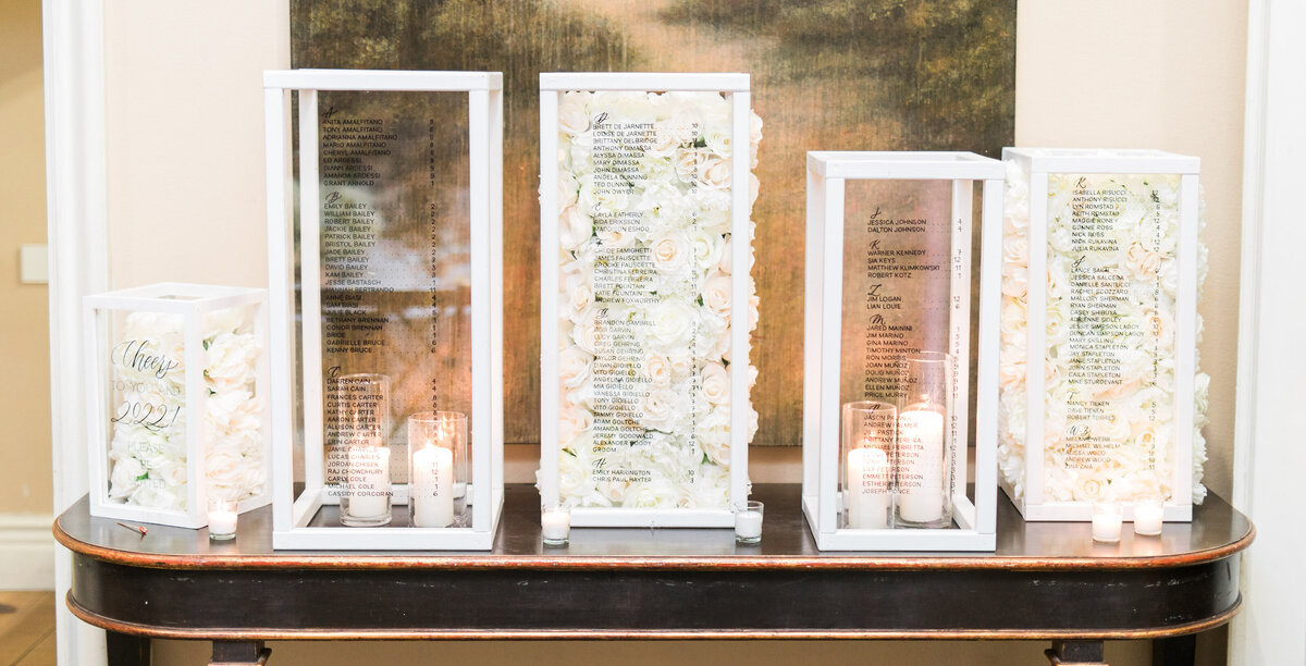 Acrylic pillars filled with florals, used as a seating chart display for a wedding in the Bay Area