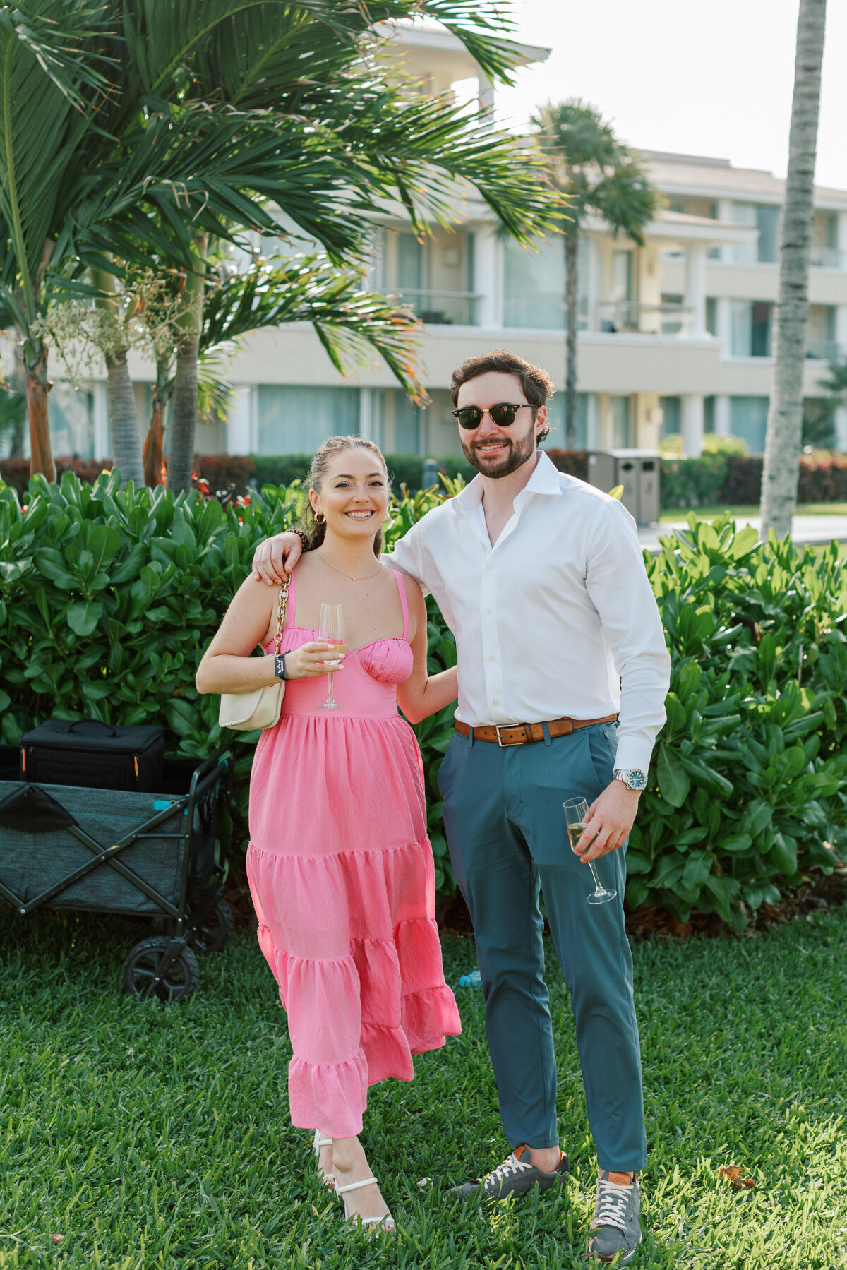Guest couple poses outdoors with champagne at a Cancun destination wedding, photographed by a Philly photographer.