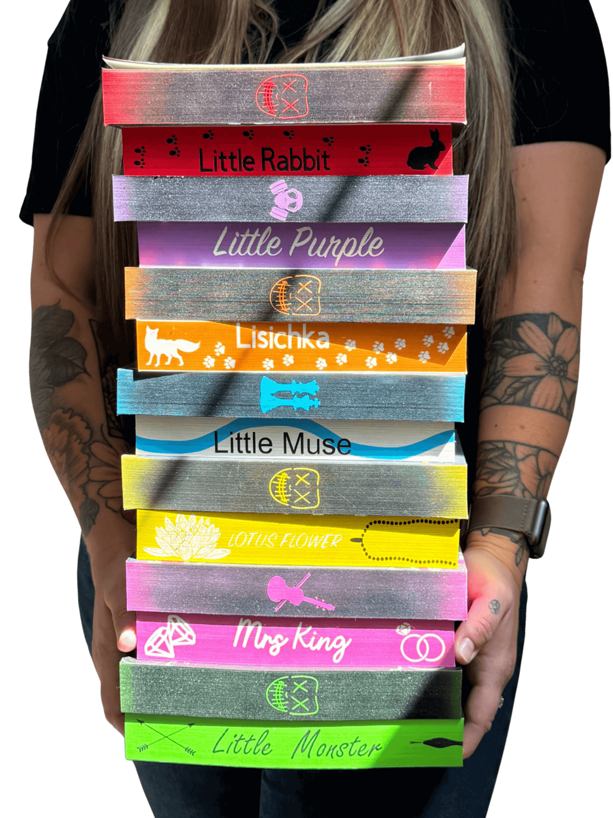 Courtney holding a stack of colorful, hand-sprayed edge books from Sprayed Your Pages.