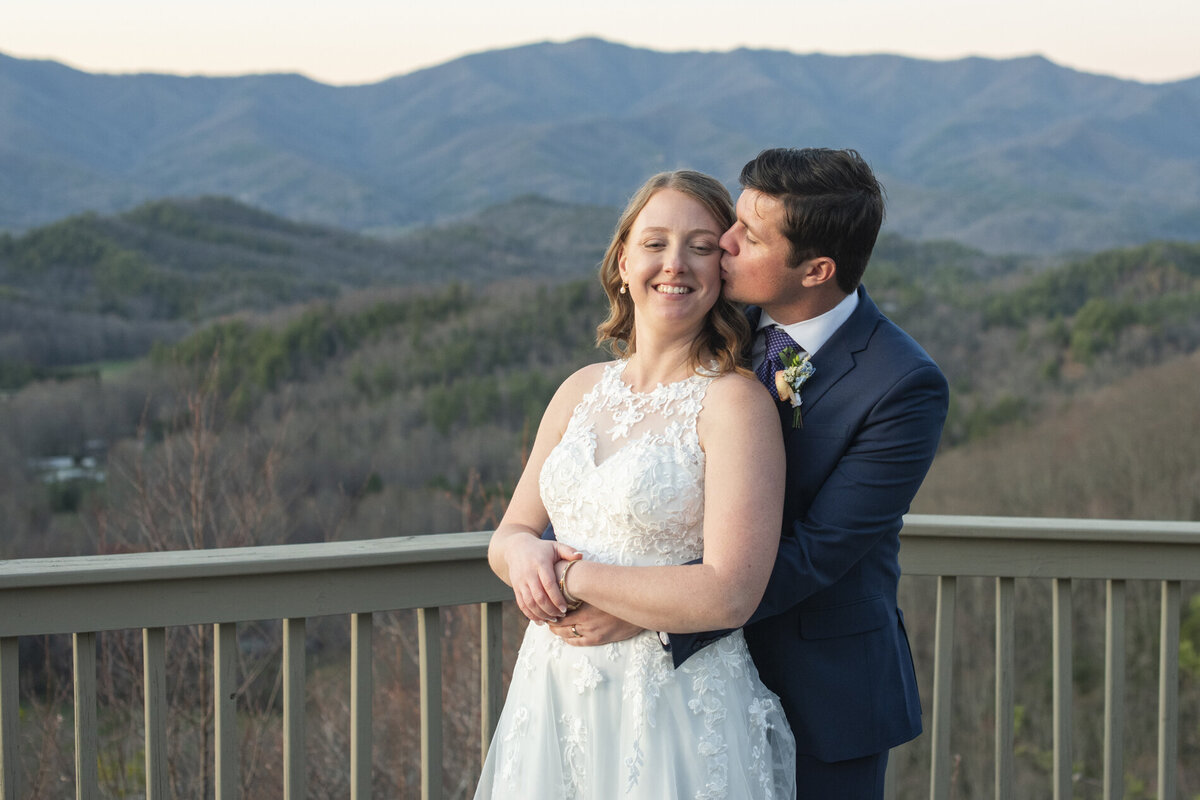 Couple snuggling on mountain top during Hawkesdene wedding photos