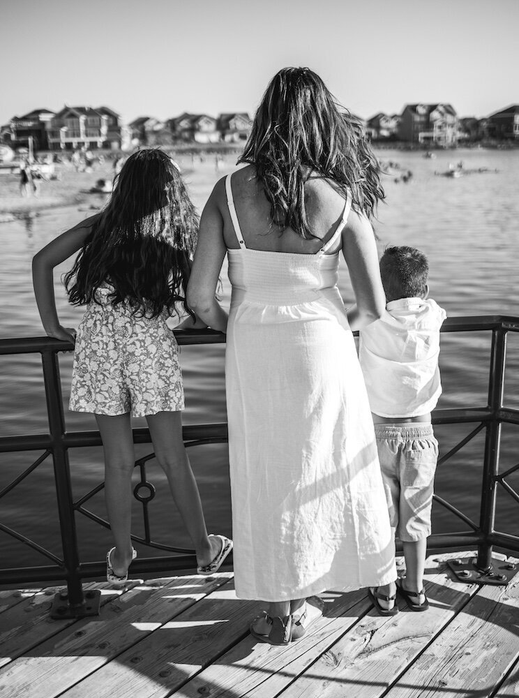 A family is standing side by side overlooking a lake near Edmonton