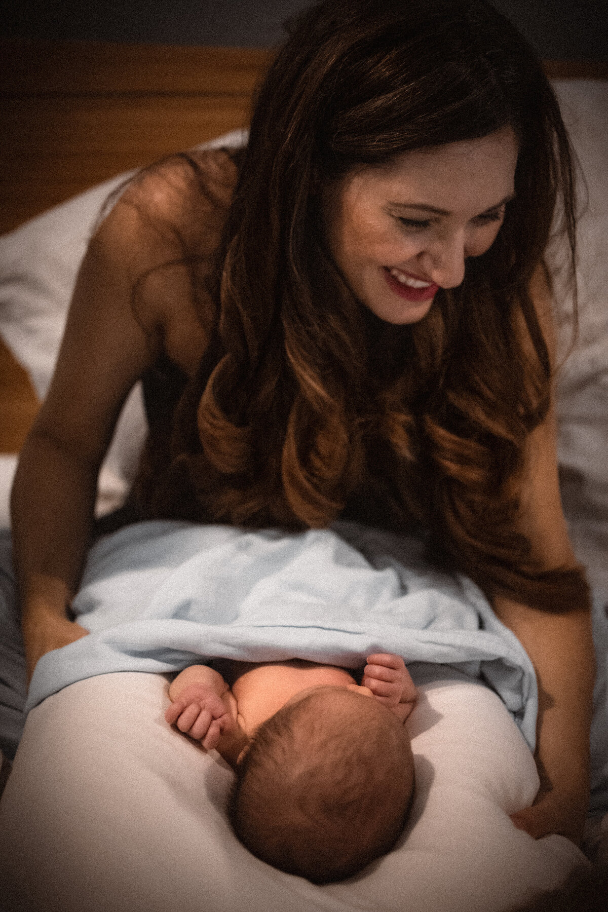 Mother smiling with newborn baby