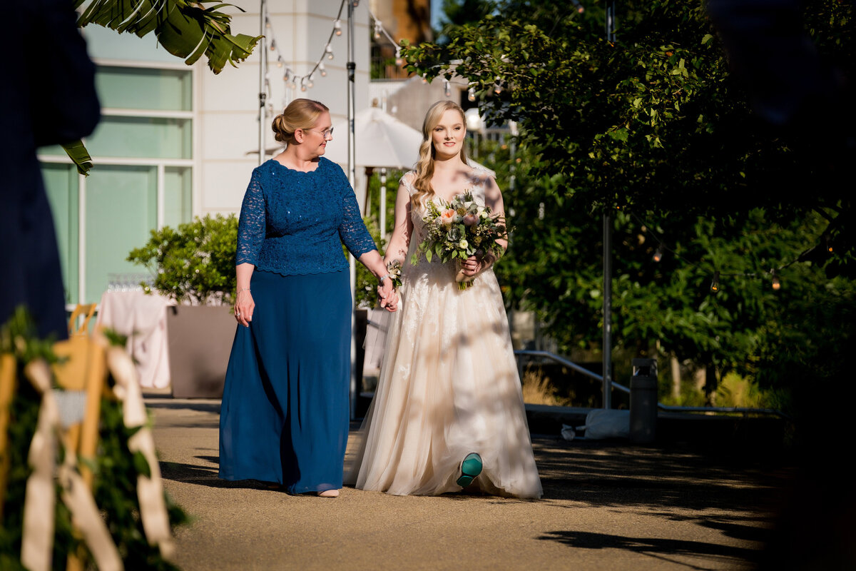 bride and mom walking down aisle