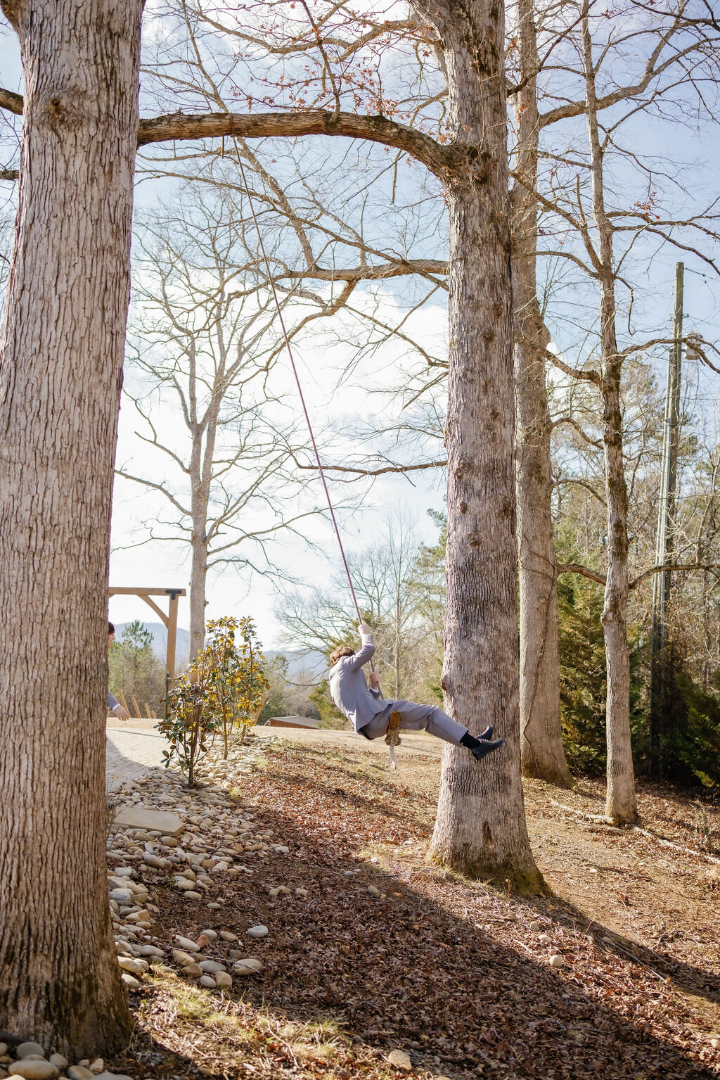 Gatlinburg elopement venue with a rope swing that the groom is swinging on