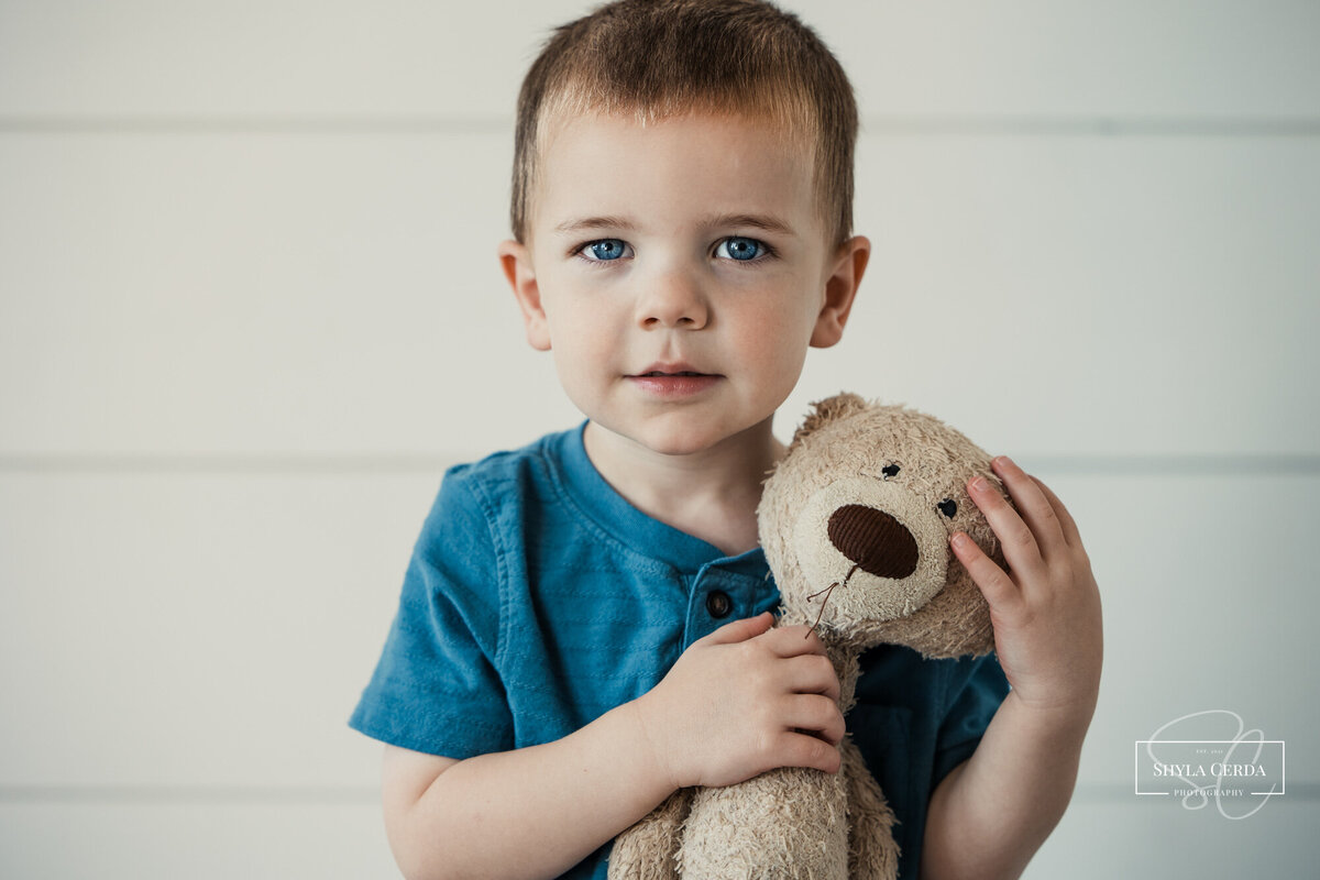 Little boy holding his stuffed bear toy