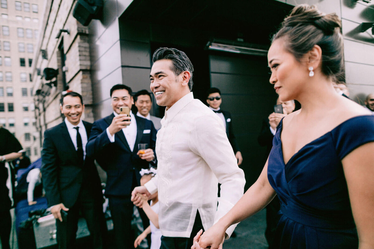 The groom is walking with a woman and a little girl in The Skylark, New York. Wedding Image by Jenny Fu Studio