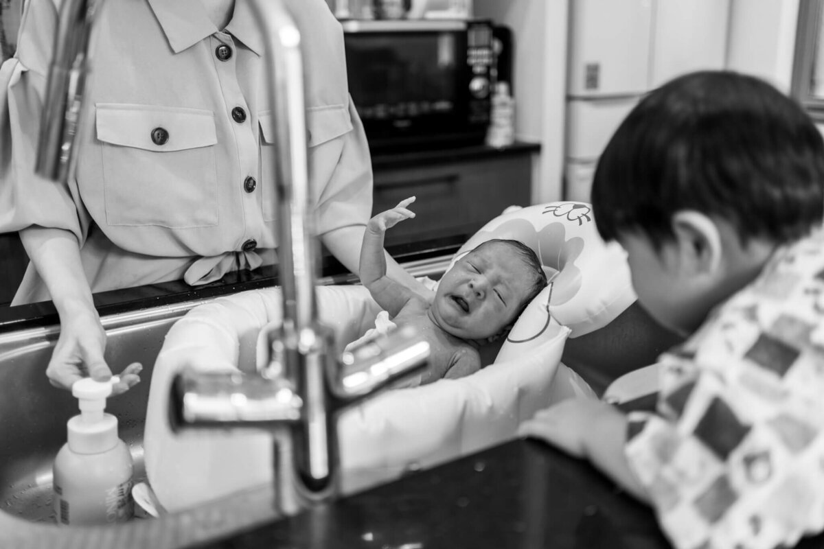 沐浴中の赤ちゃんの白黒写真