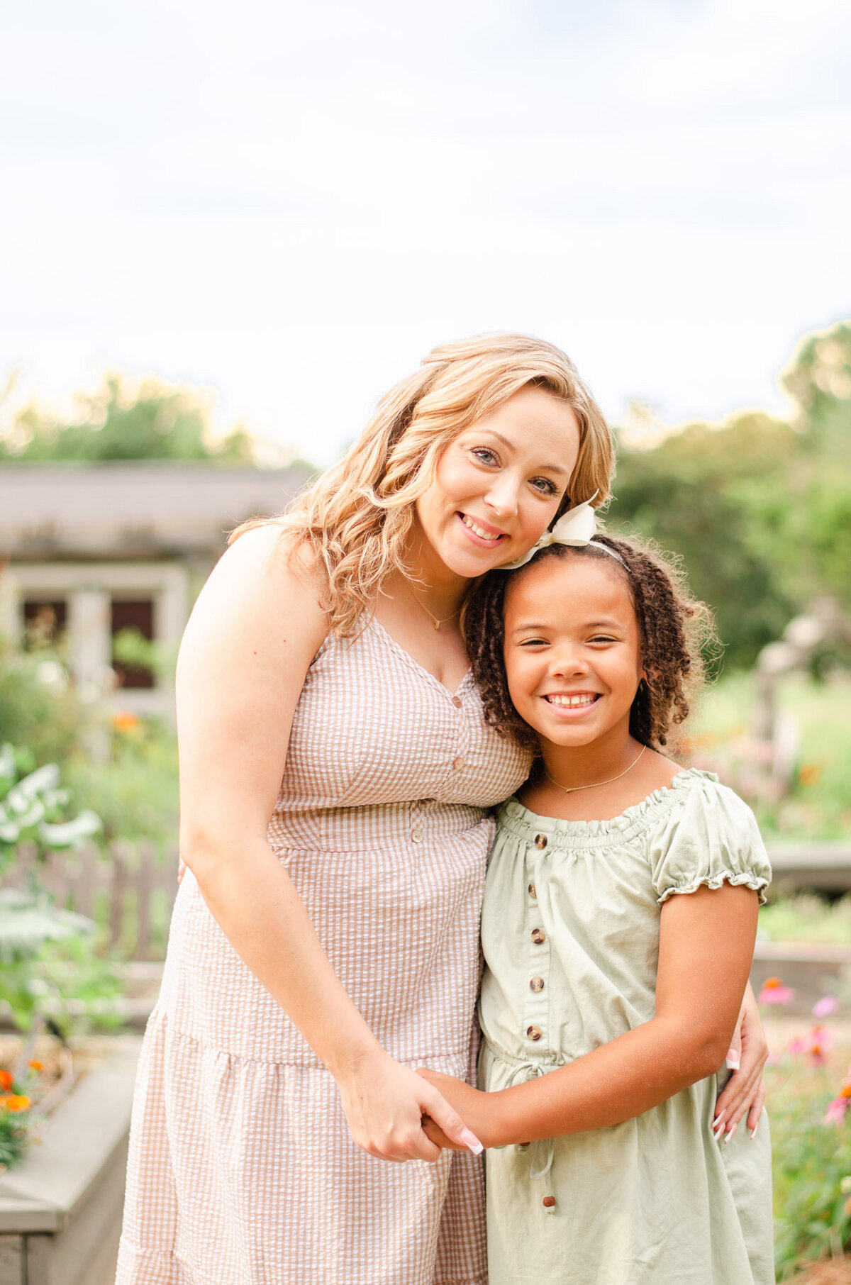 mother and daughter embrace in a flower garden