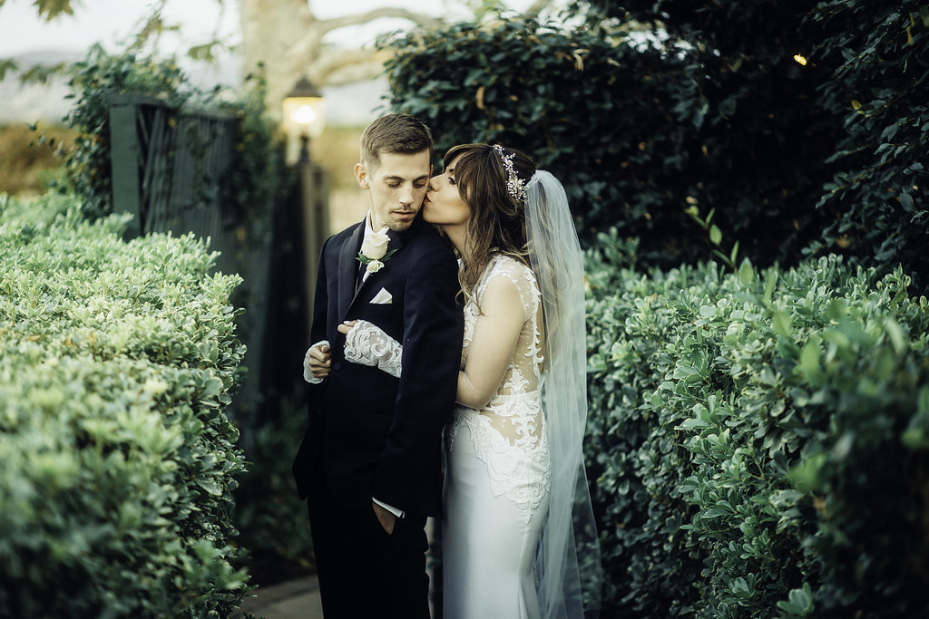 Wedding Photograph Of Bride Kissing Her Groom On His Cheeks Los Angeles