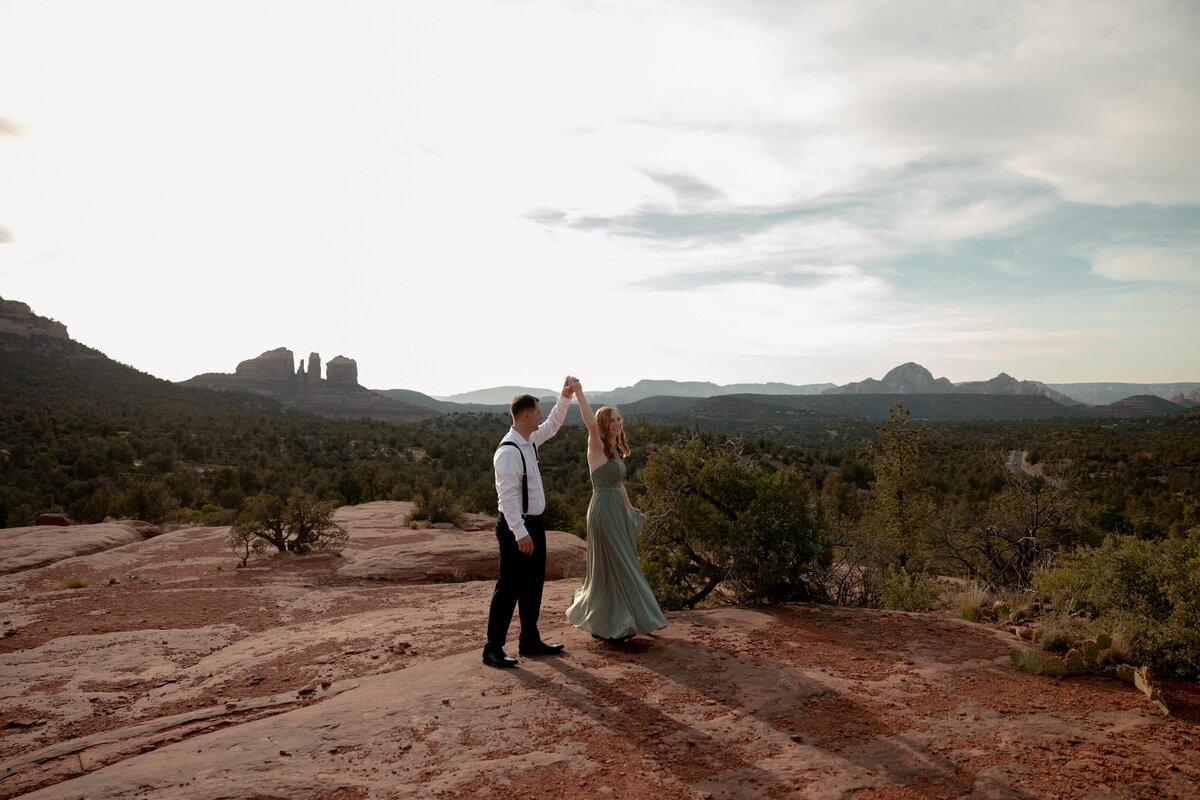 Couple standing against red rock backdrop during Sedona engagement session