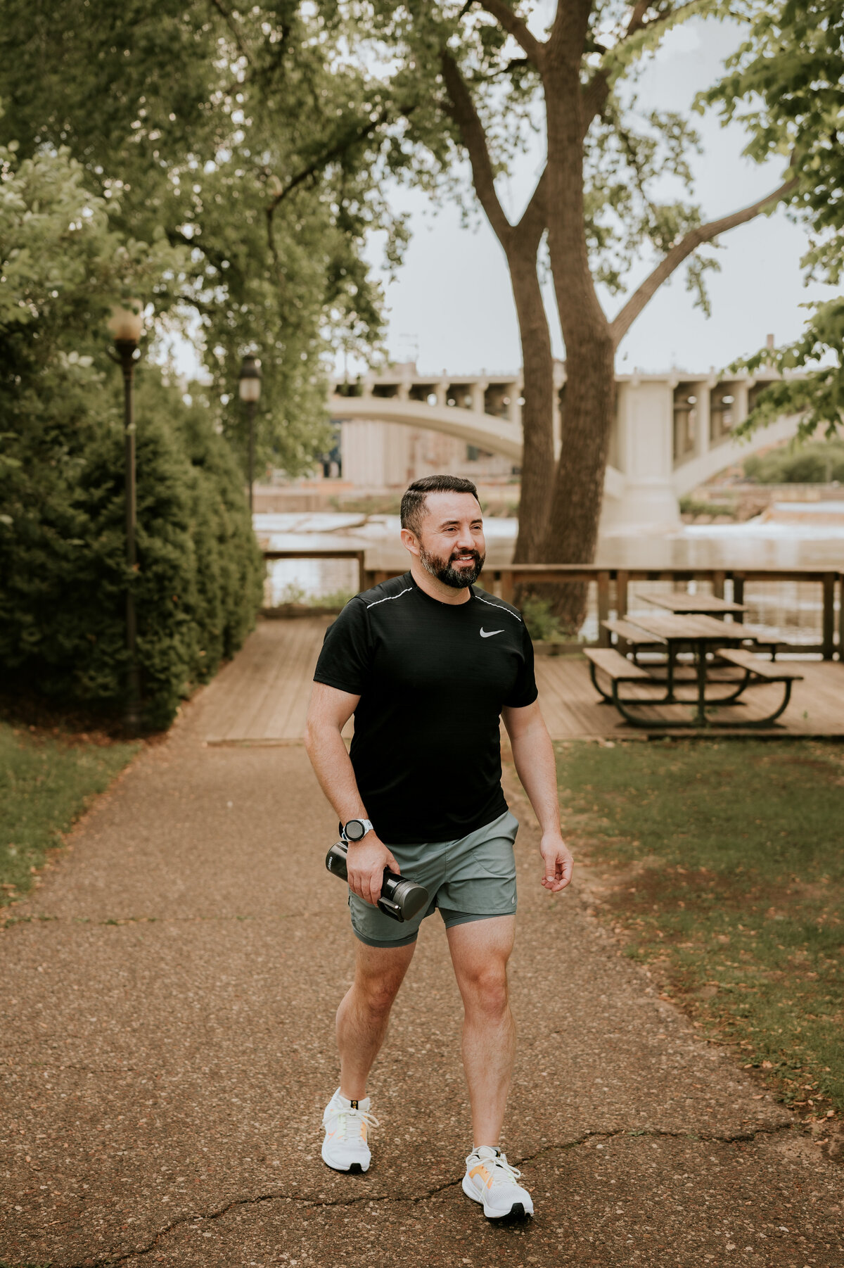 Professional outdoor dating profile photo of a man walking along a city trail in casual activewear, perfect for dating apps like Bumble and Hinge.