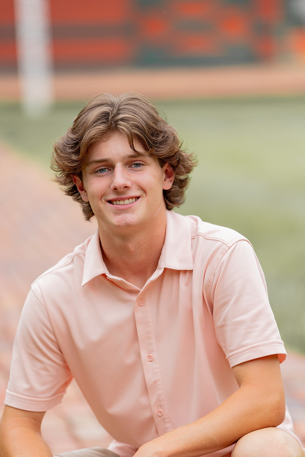 senior squatting and smiling on brick path