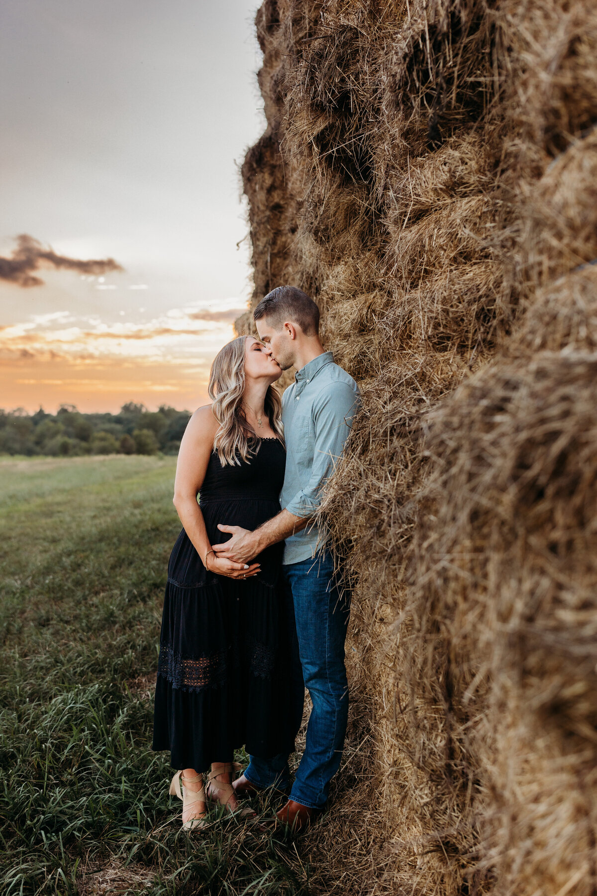 pregnant mother and husband kissing by hay stacks by harrisburg pa maternity photographer