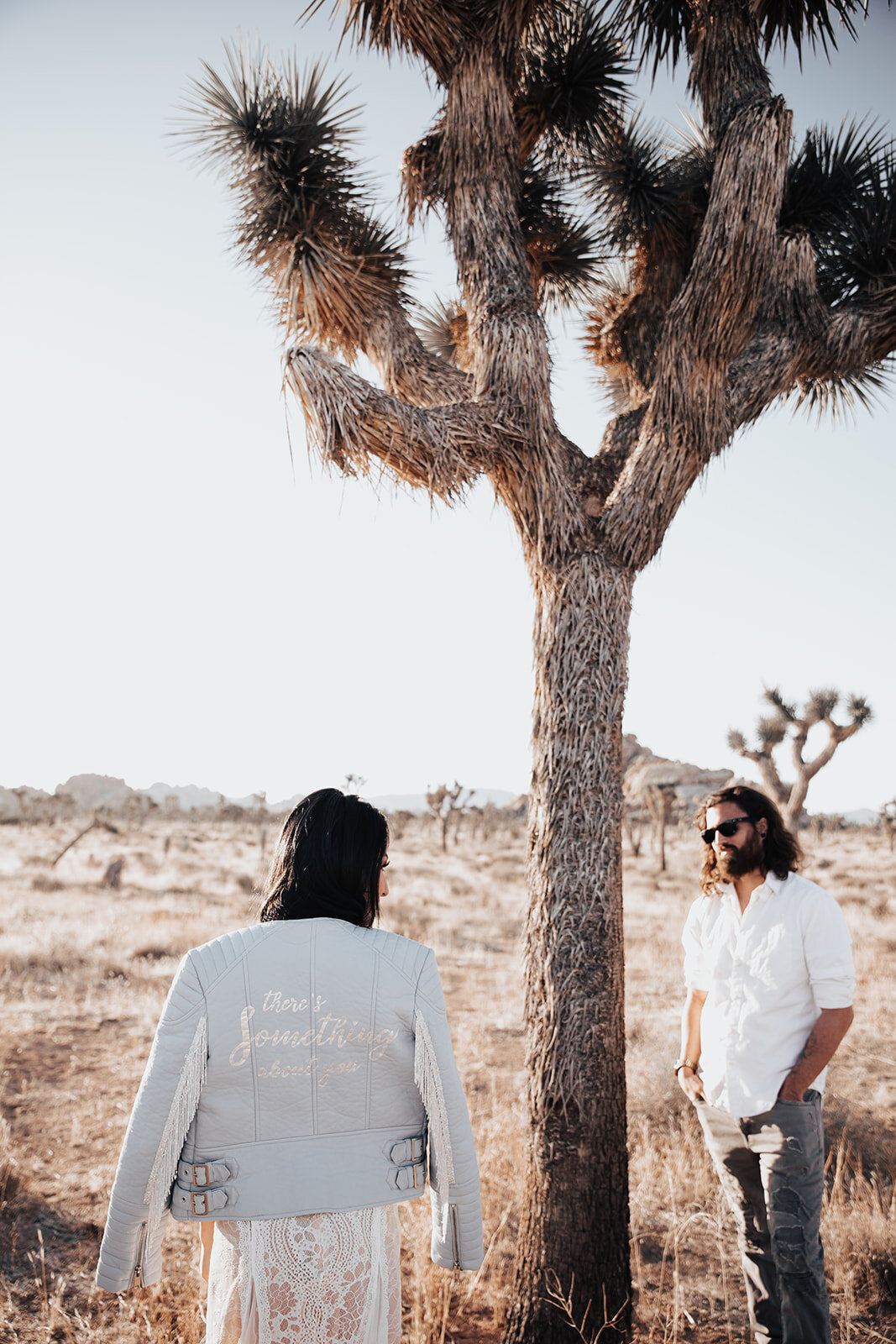 Casual bride and groom looking at each other next to Joshua Tree