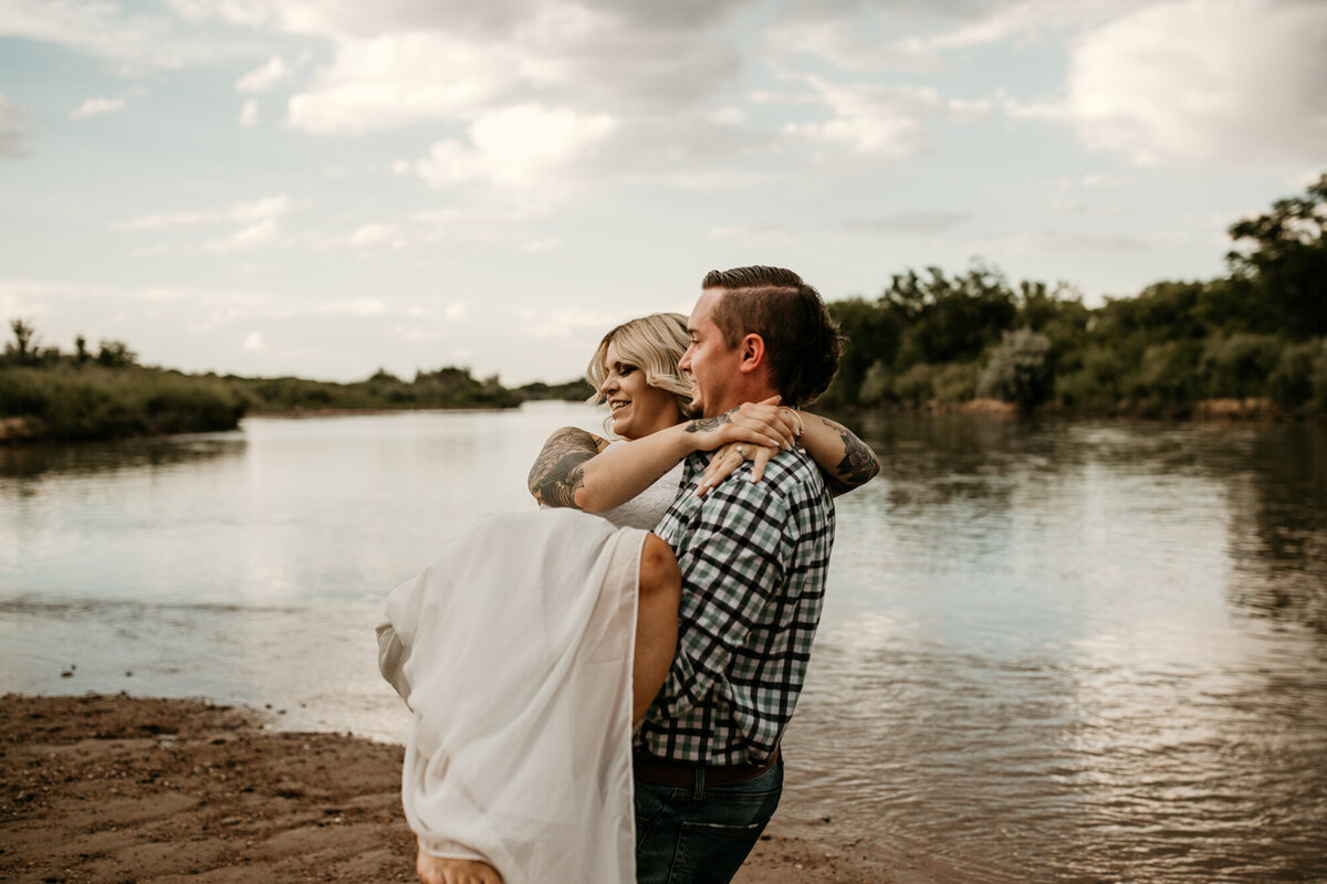 groom carrying bride by the Rio Grande river