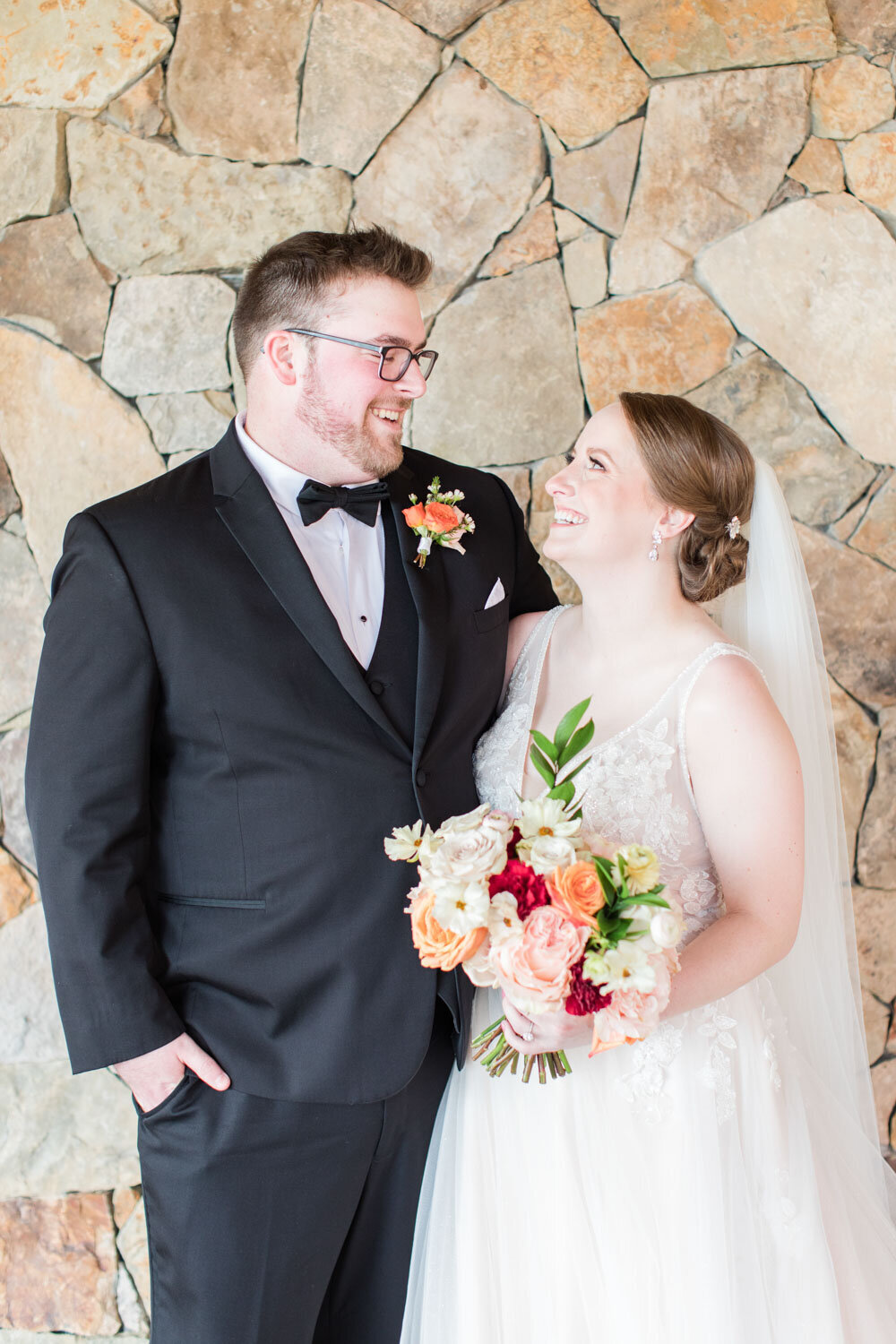 Bride and groom starring and smiling at each other