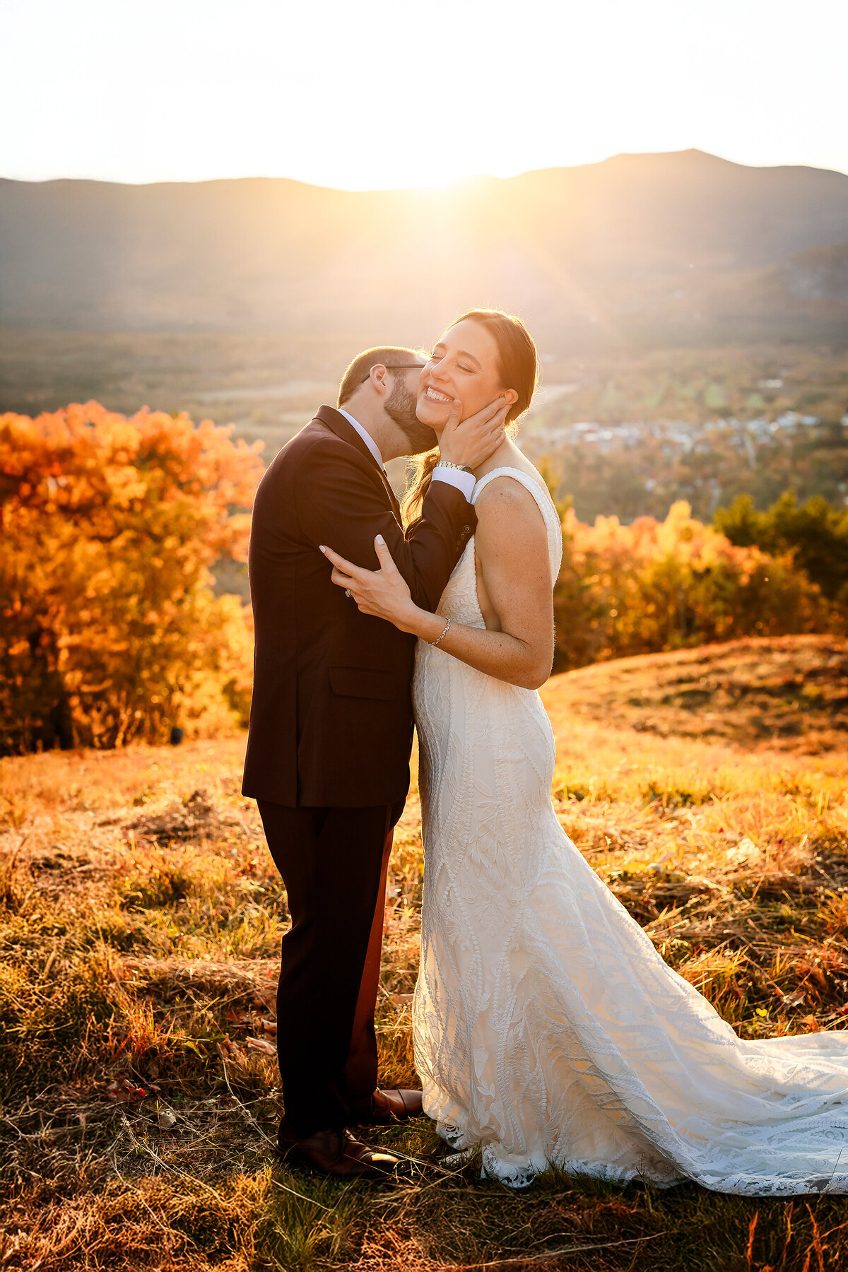 Groom kissing brides neck on summit of Cranmore Mountain in North Conway NH