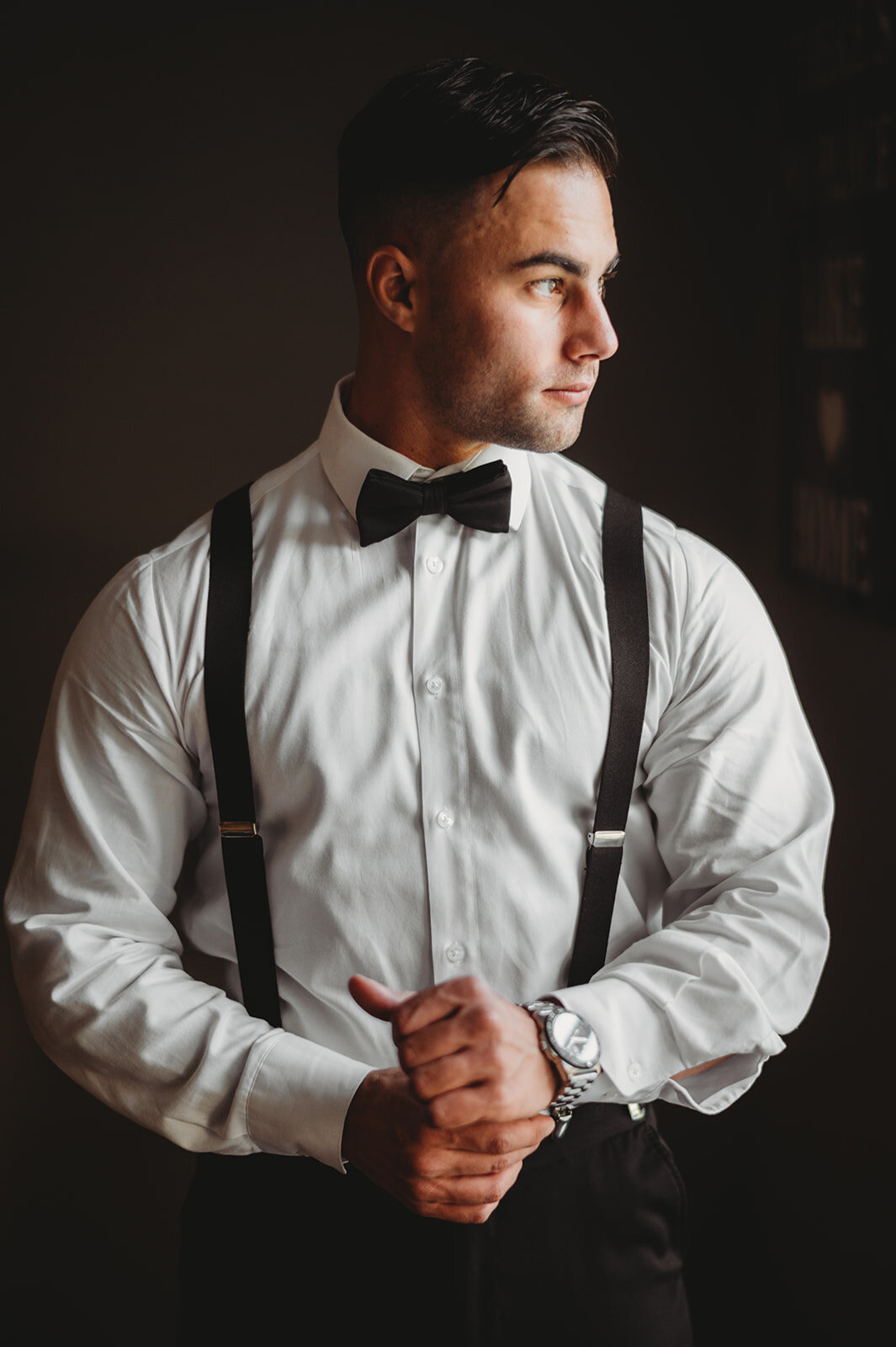 groom adjusts his shirt sleeves preparing for his new haven lawn club wedding photo by cait fletcher photography