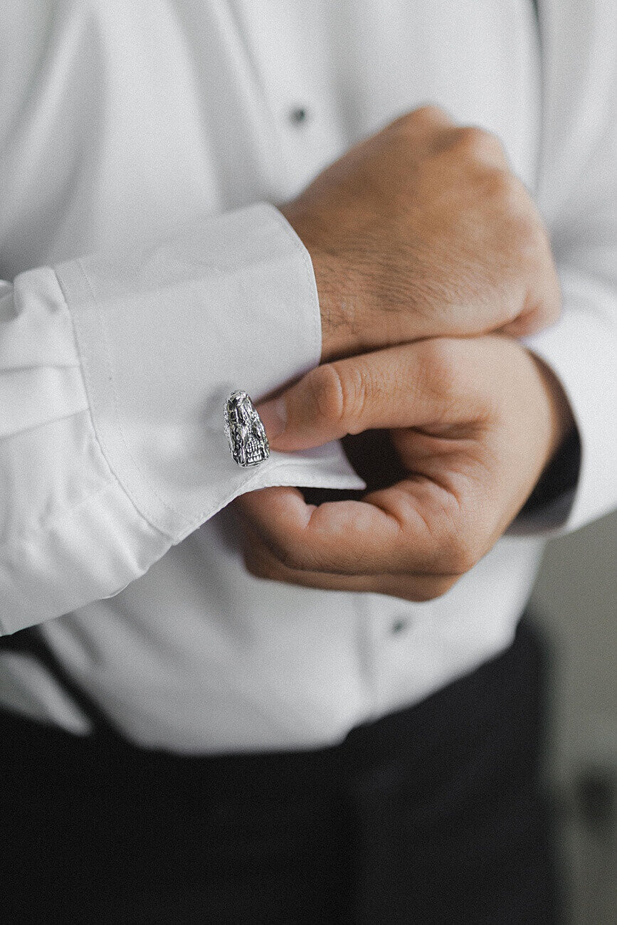 groom's hands as he fixes his alligator cuff links
