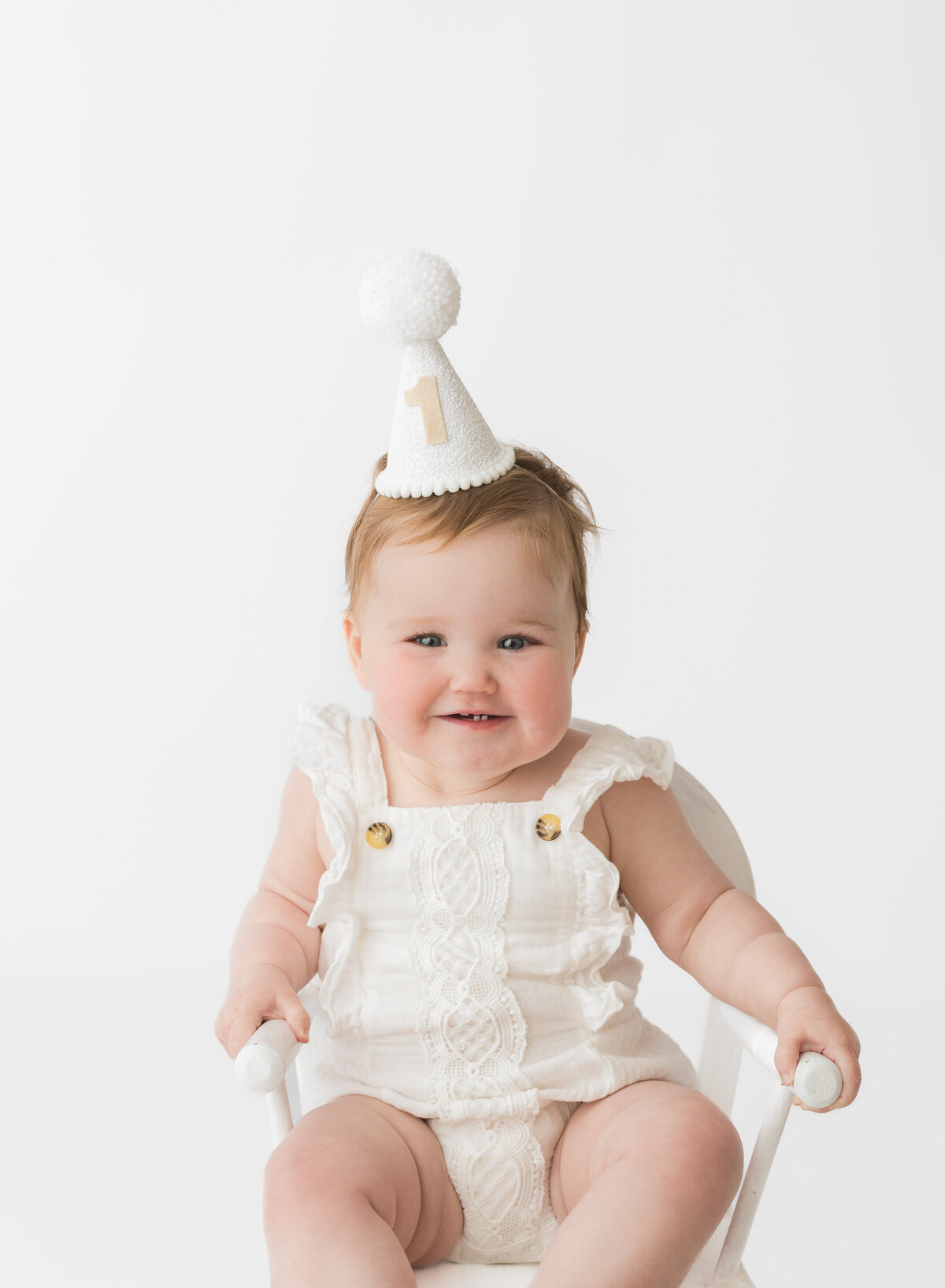 Baby wearing a party hat at a first birthday photoshoot by Hobart Photographer Lauren Vanier