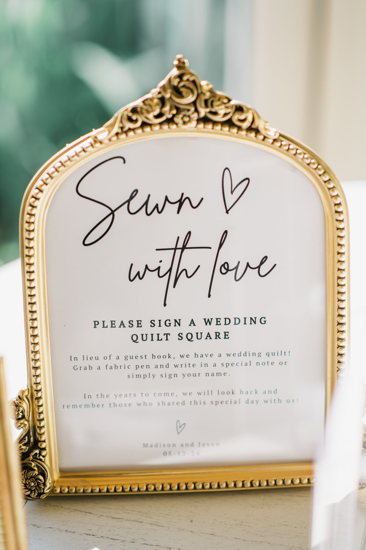 Wedding guest book alternative sign reading “Sewn with Love,” inviting guests to sign a quilt square at Old Edwards Inn in Highlands, North Carolina.

