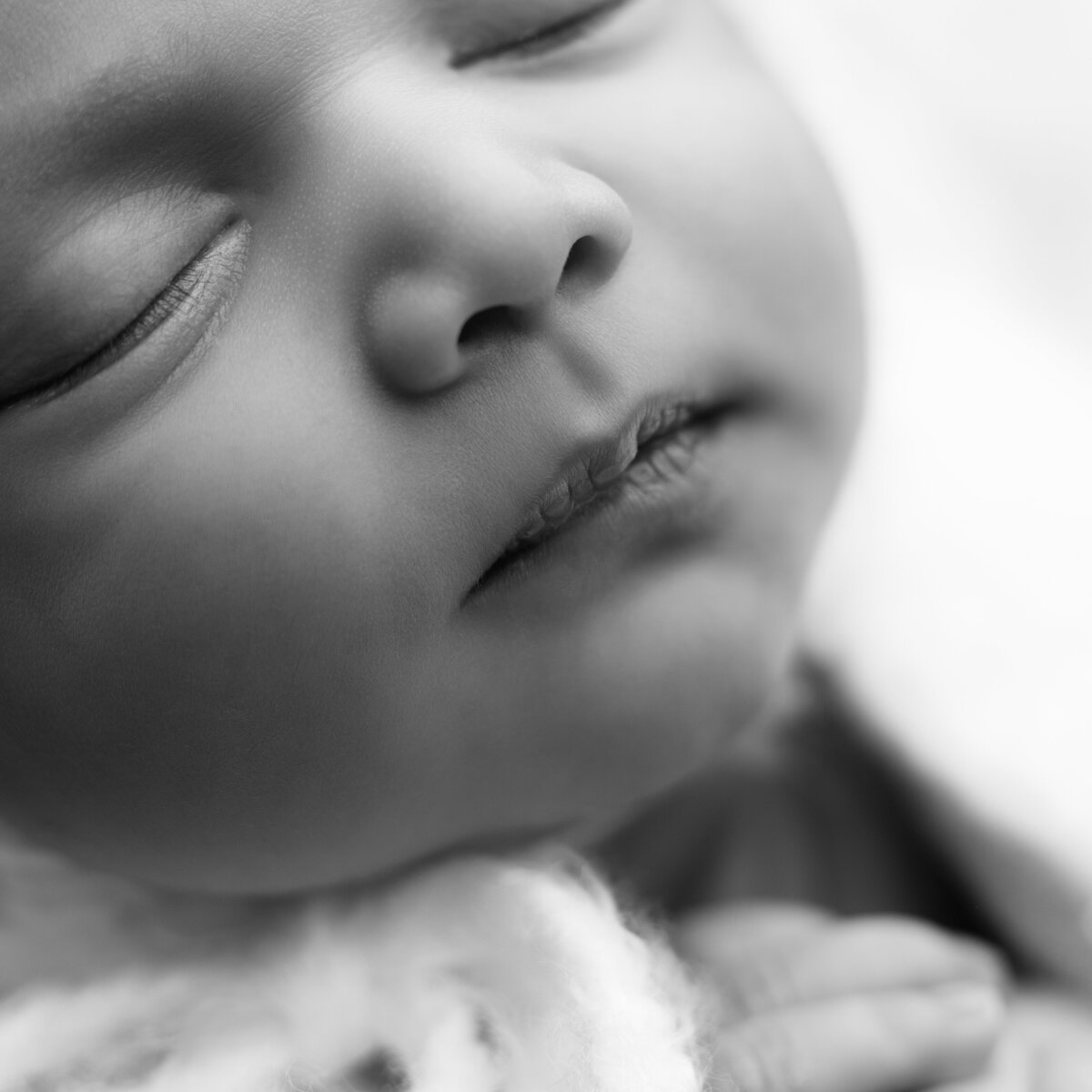 A fleeting newborn smile, gently caught in a macro moment—where every curve speaks joy.