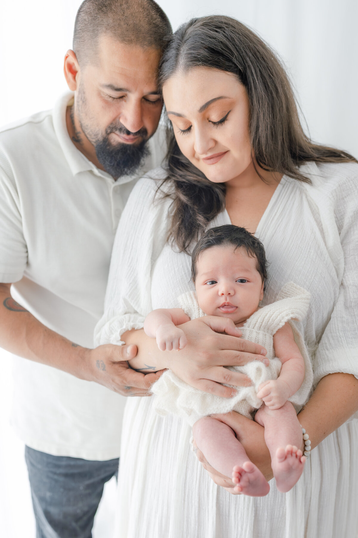 Parents holding baby during natural light Barrie newborn photography session 