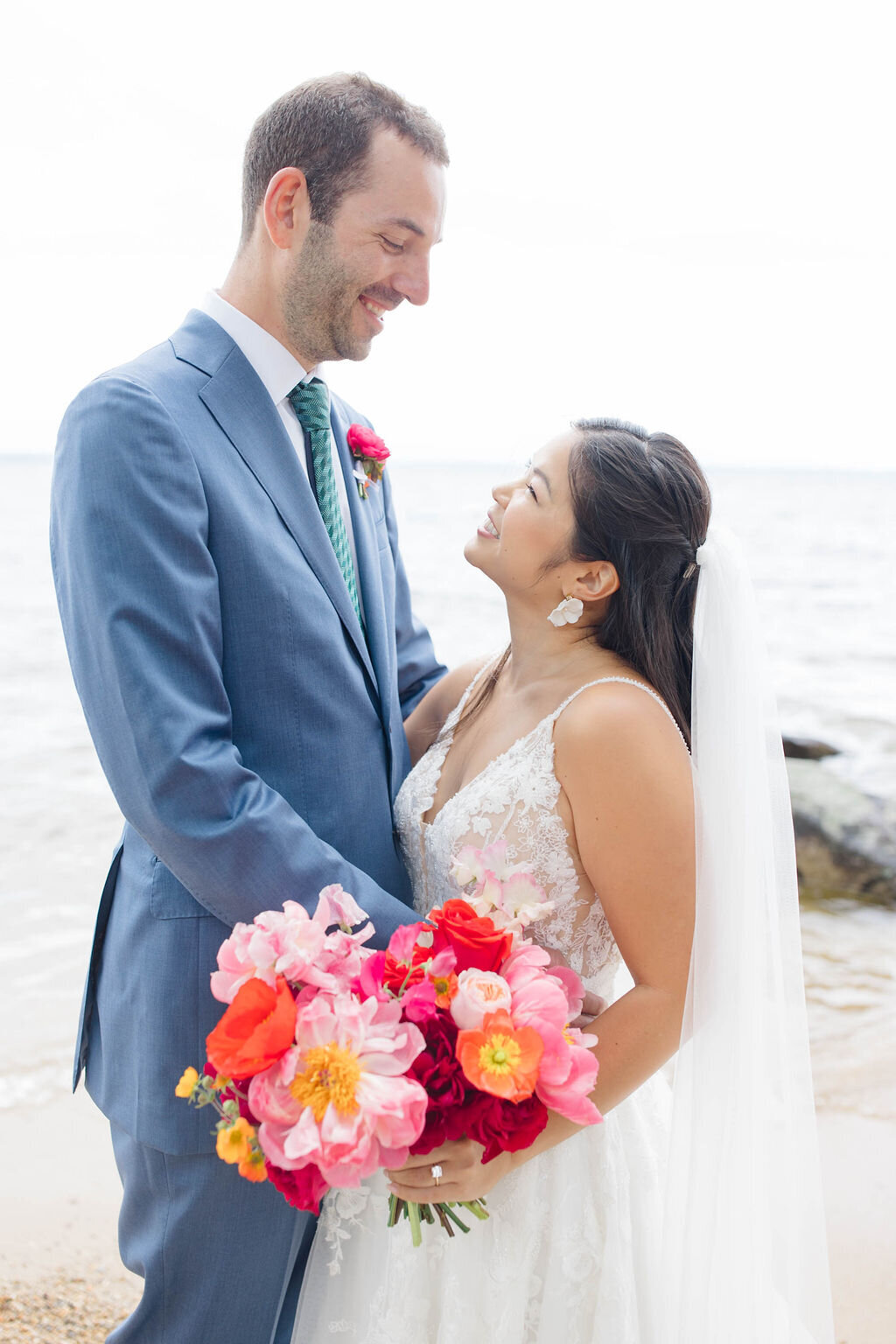 Couple smiling at each other with colorful floral bouquet