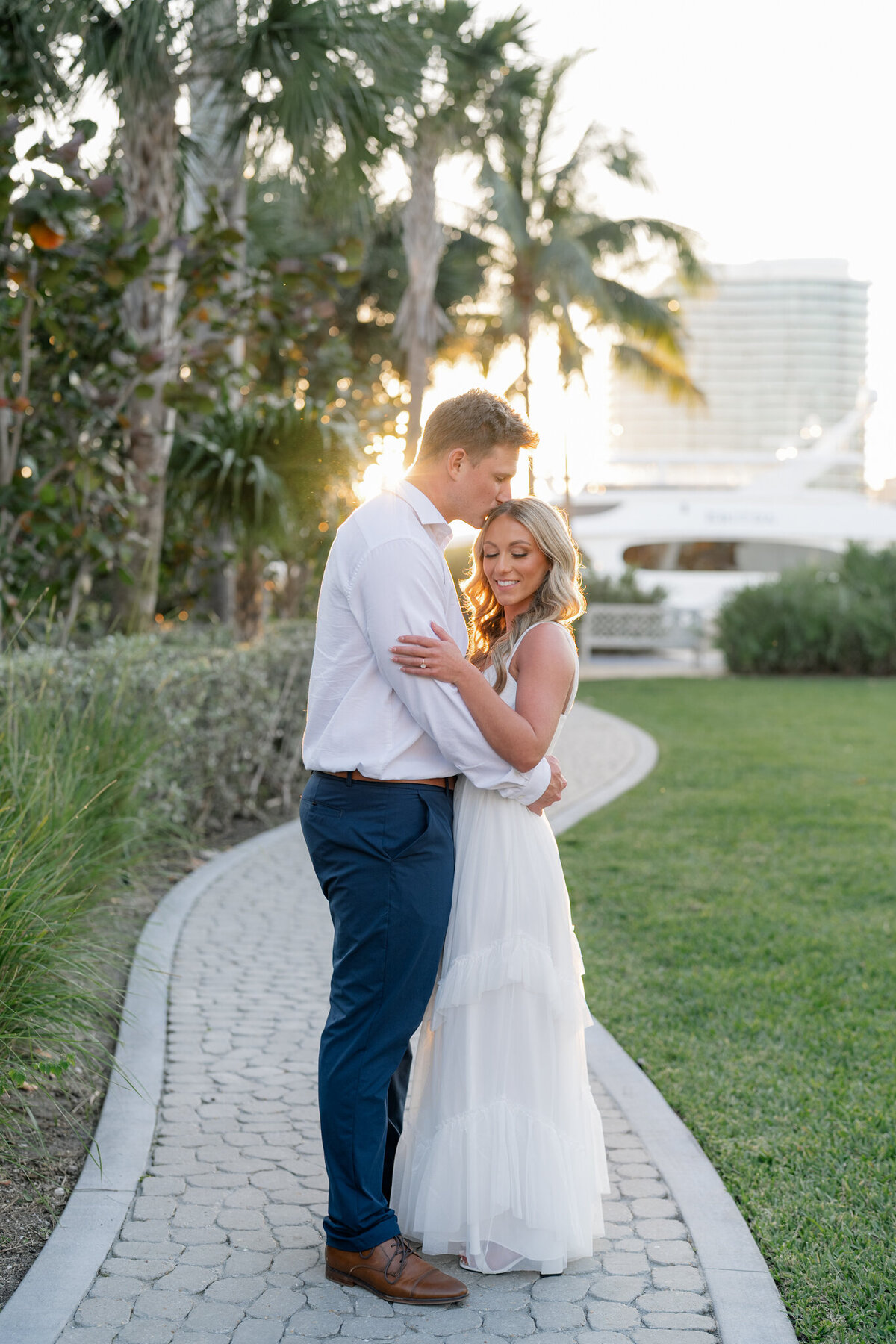 Man kissing woman on temple while hugging