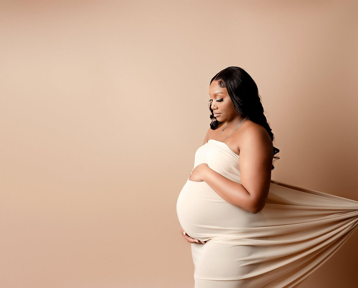 A blissful mom-to-be posing elegantly in a Brooklyn studio, celebrating the miracle of life.