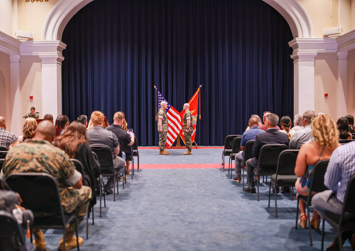 military man getting promoted in a hall with family and friends watching