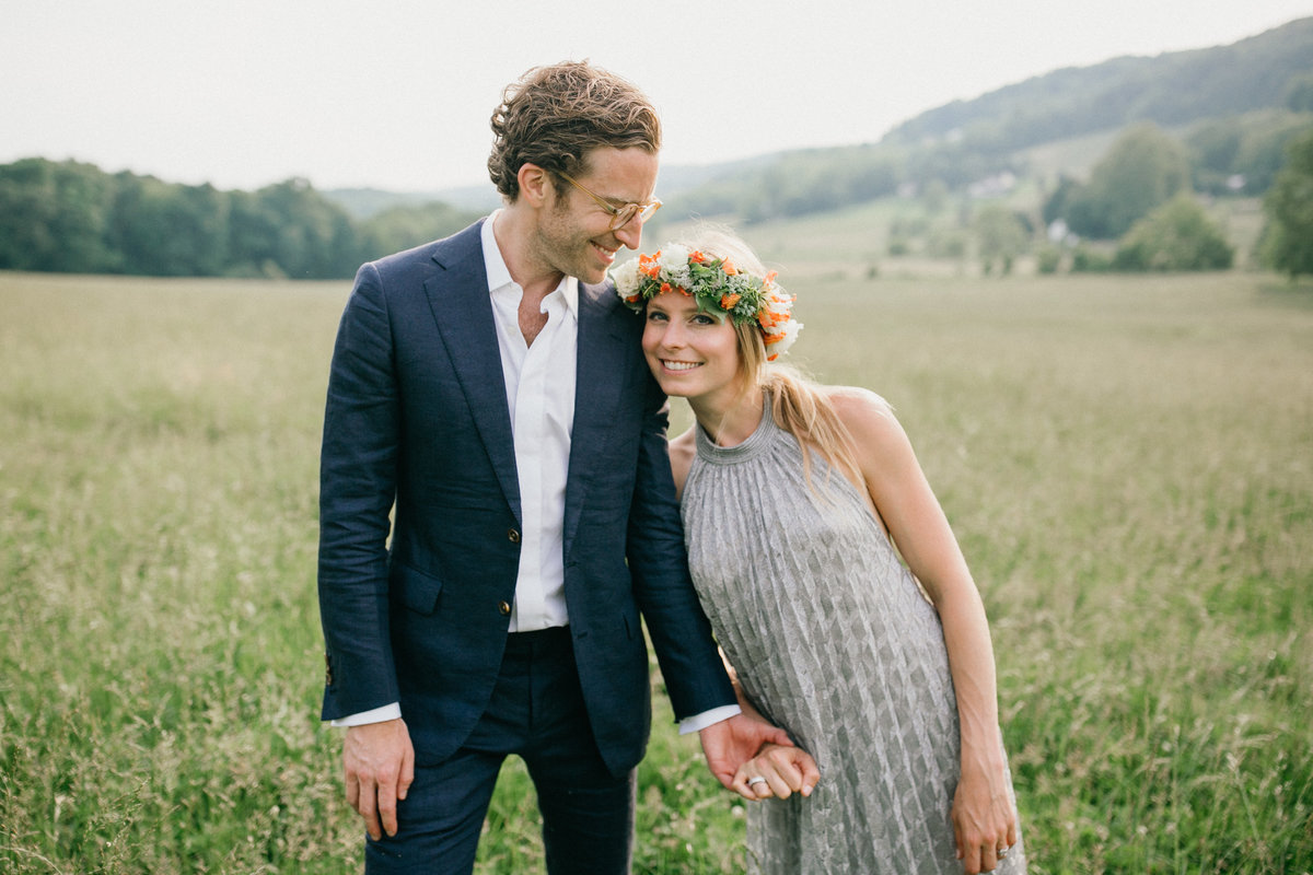 Bride and groom photographed on the bride's family farm at their welcome party for their wedding guests.