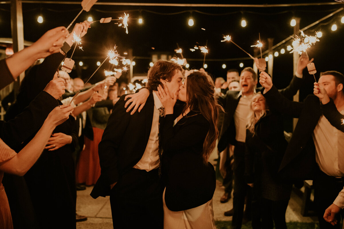 bride and groom kissing during their sparkler wedding exit