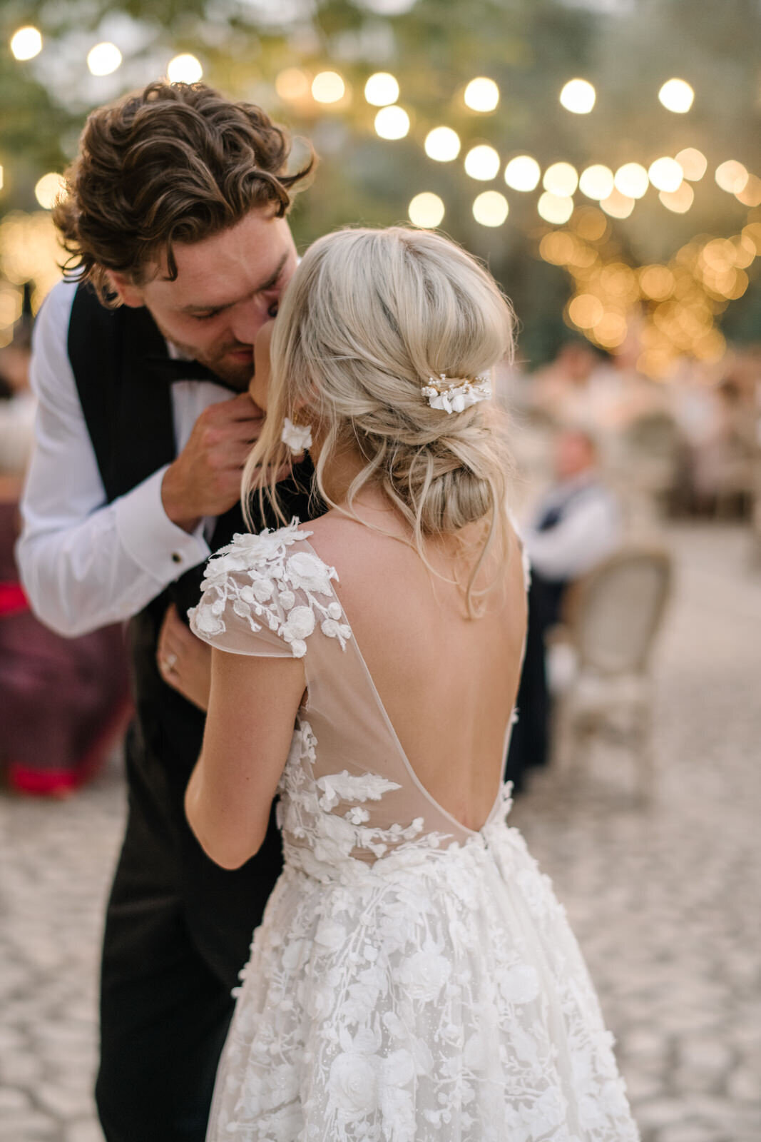 bride and groom kissing under fairy lights at finca wedding in mallorca