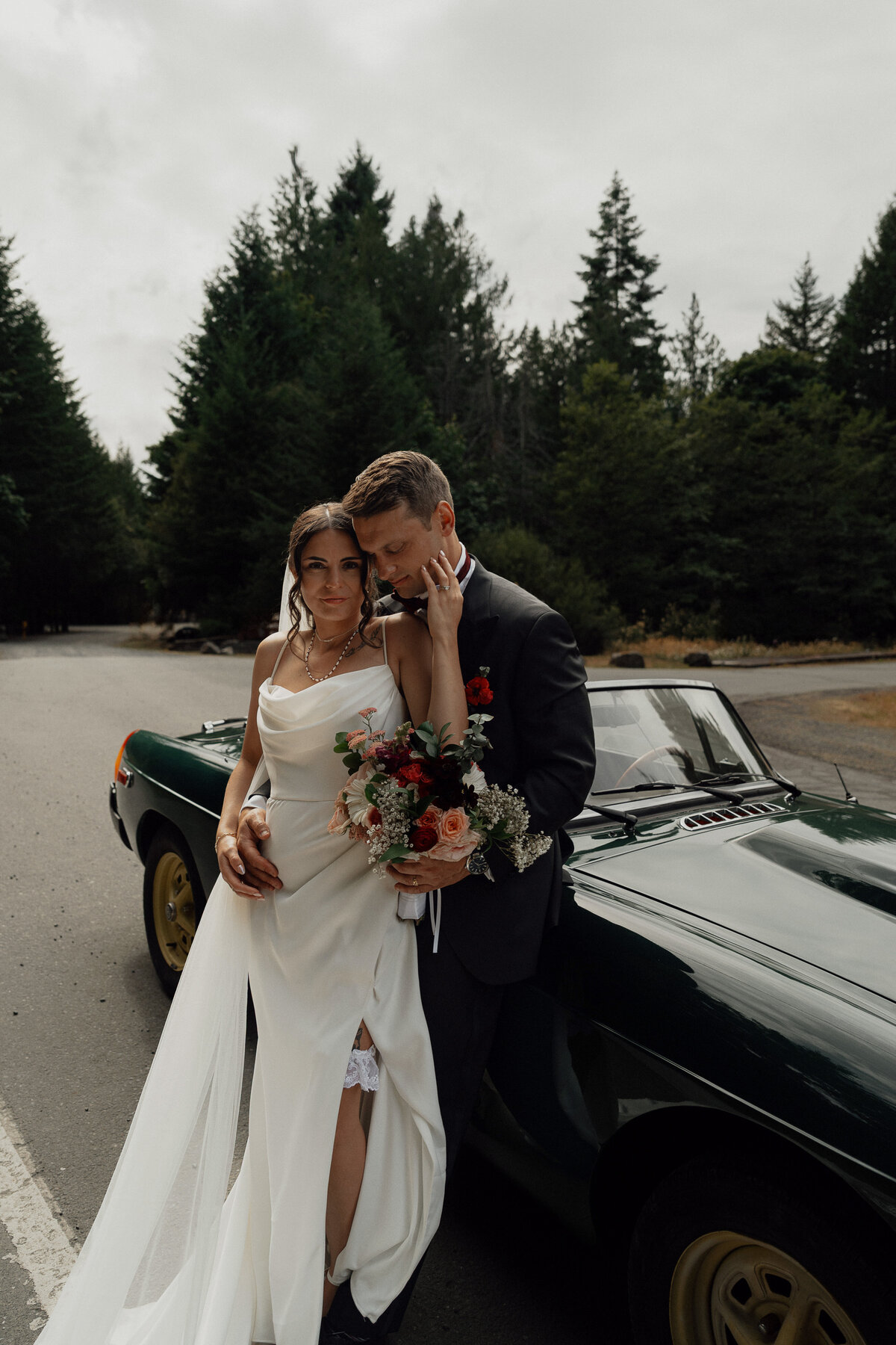 Bride and Groom leaning agains their MGB during wedding portraits at Caleb Pike Heritage Park in Victoria by Latitude 49 Photography