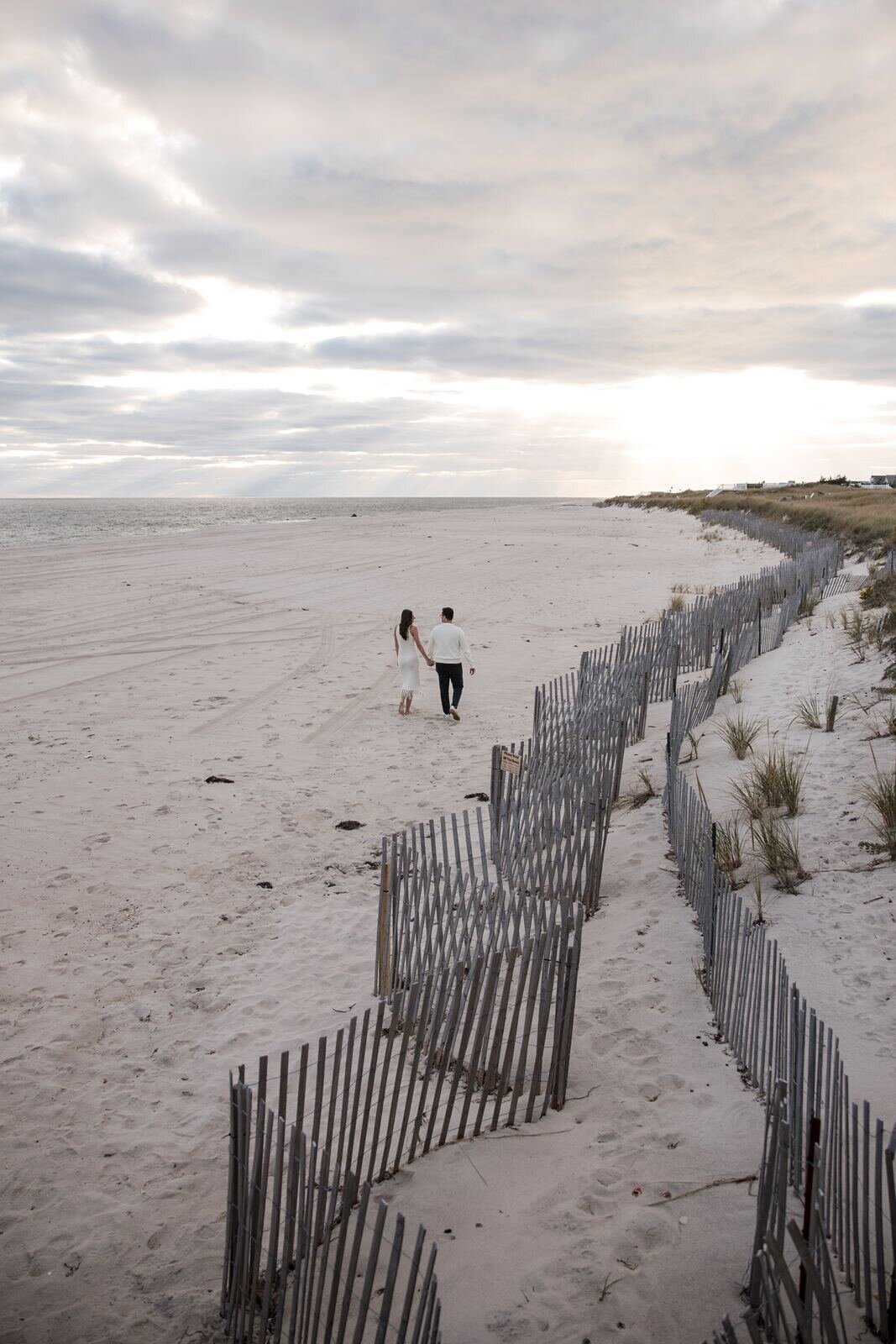 Couple walking through the dunes of West Hampton.