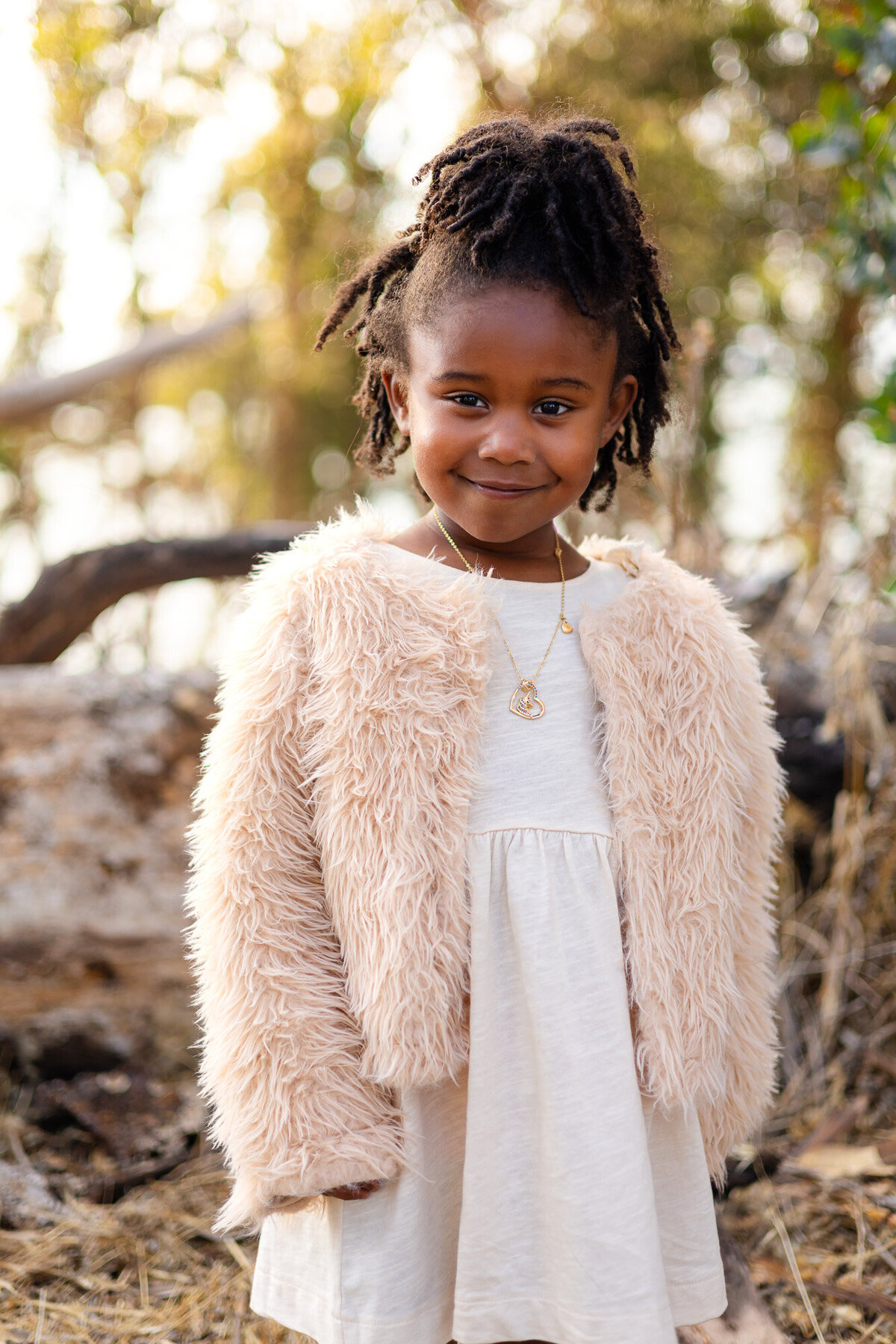 Young girl smiling in cream dress and fuzzy jacket Bay Area Family Portfolio – Ellobelle Photography