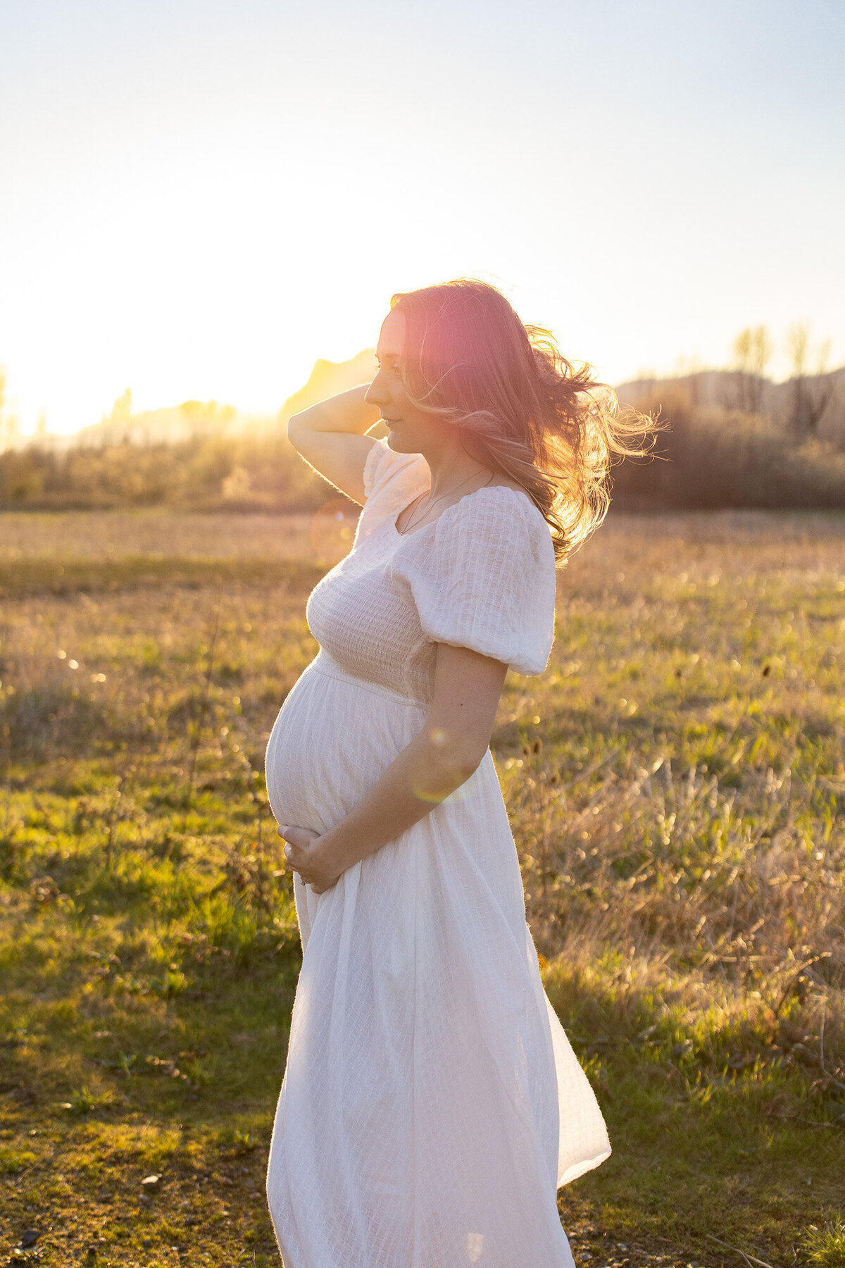 Oregon maternity photographer captures mom-to-be in field at sunset.