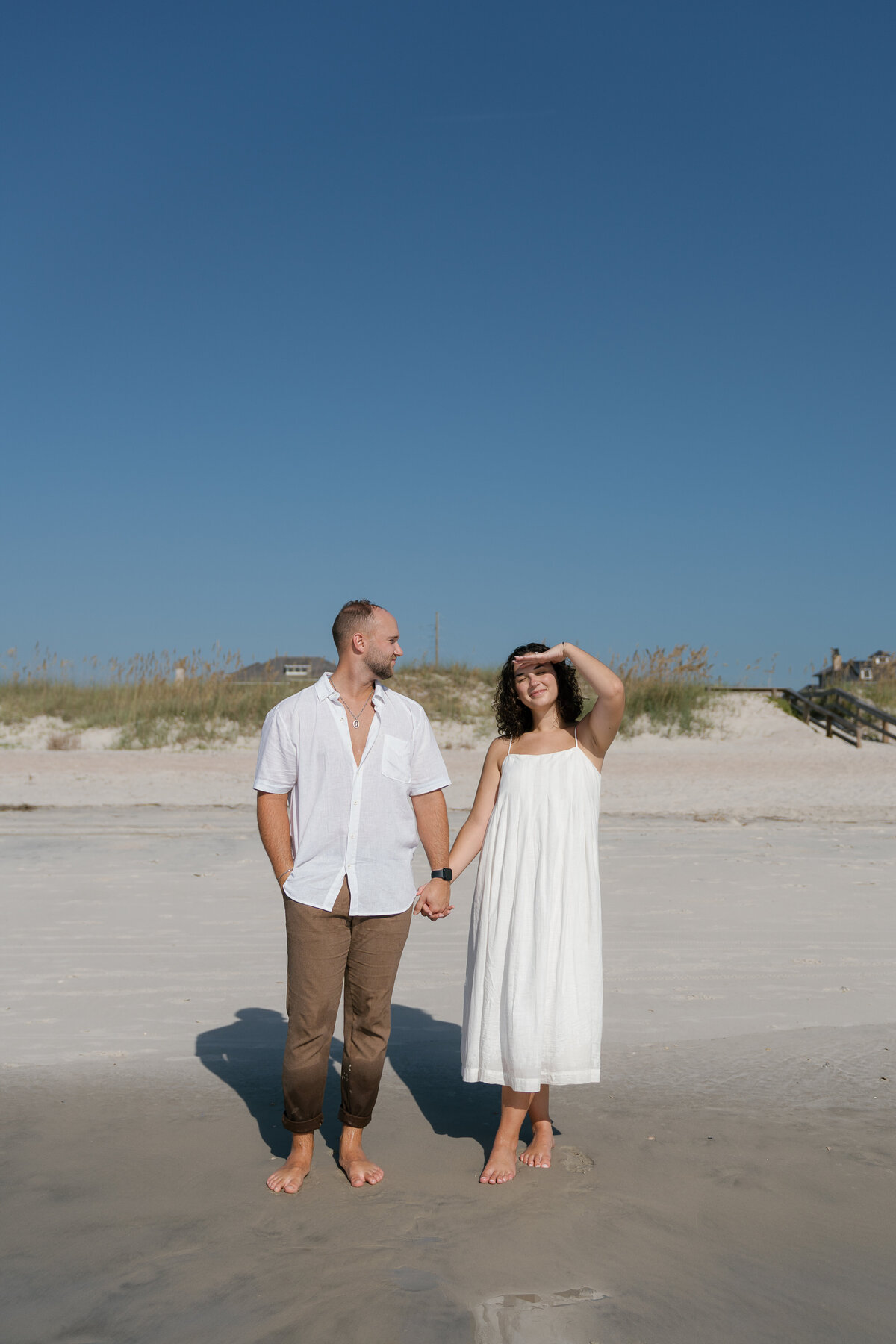 Couple holding hands and posing for engagement photography in florida