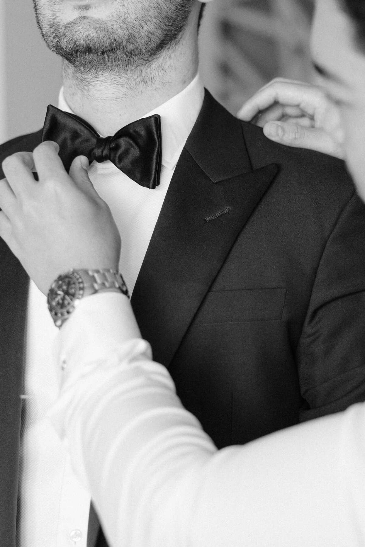 Groom having bowtie fixed by groomsman at alohilani hotel