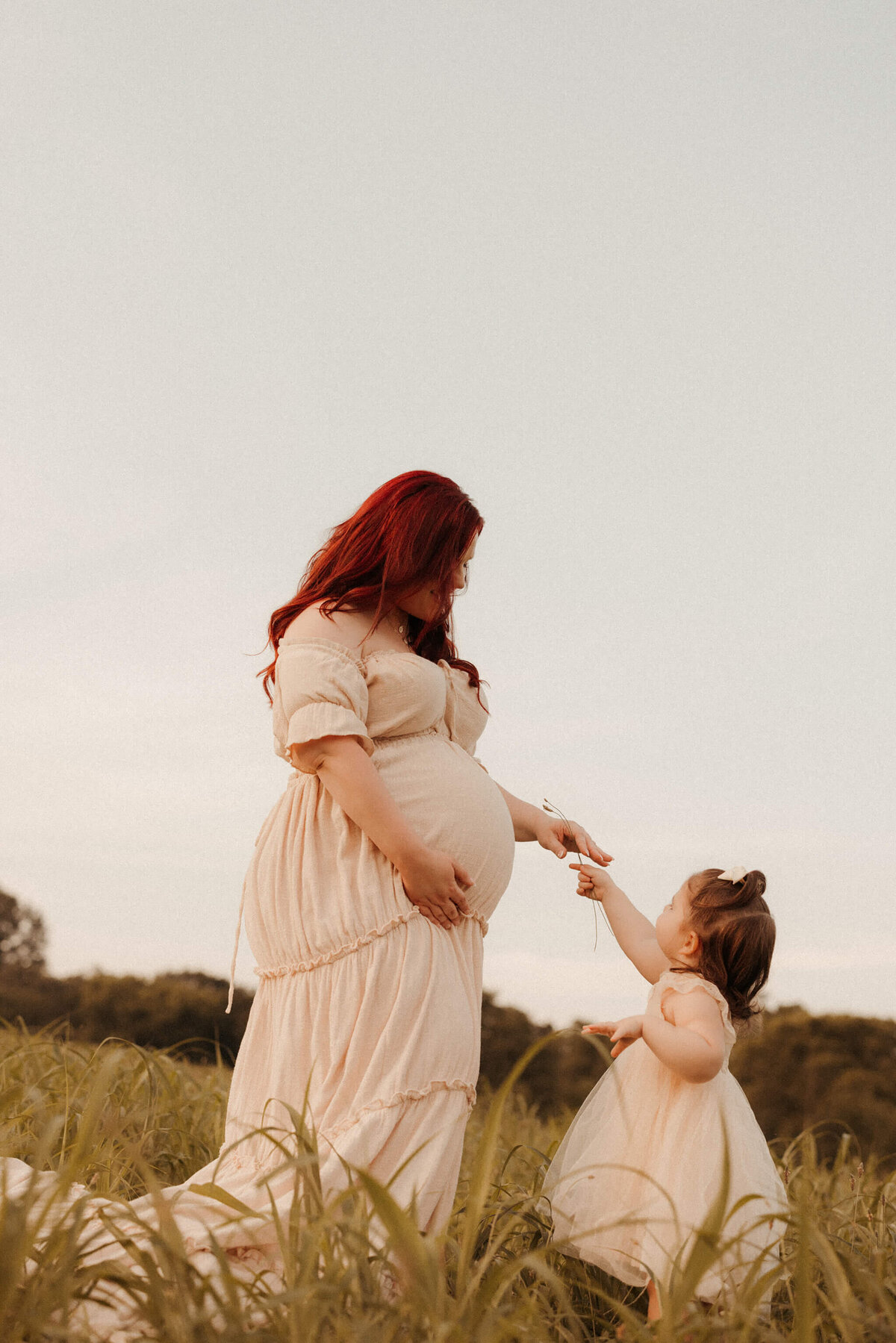 Pregnant woman sitting on bed during cozy in-home maternity photos in Franklin Tennessee