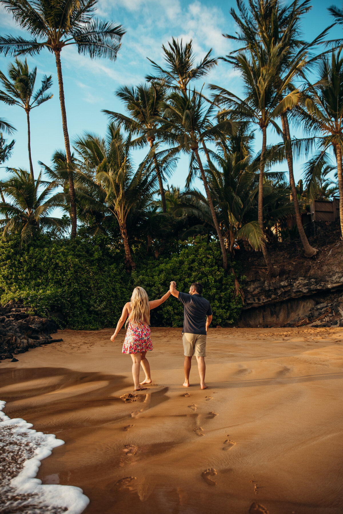 Hawaii Engagement Photographer captures couple walking hand in hand down beach