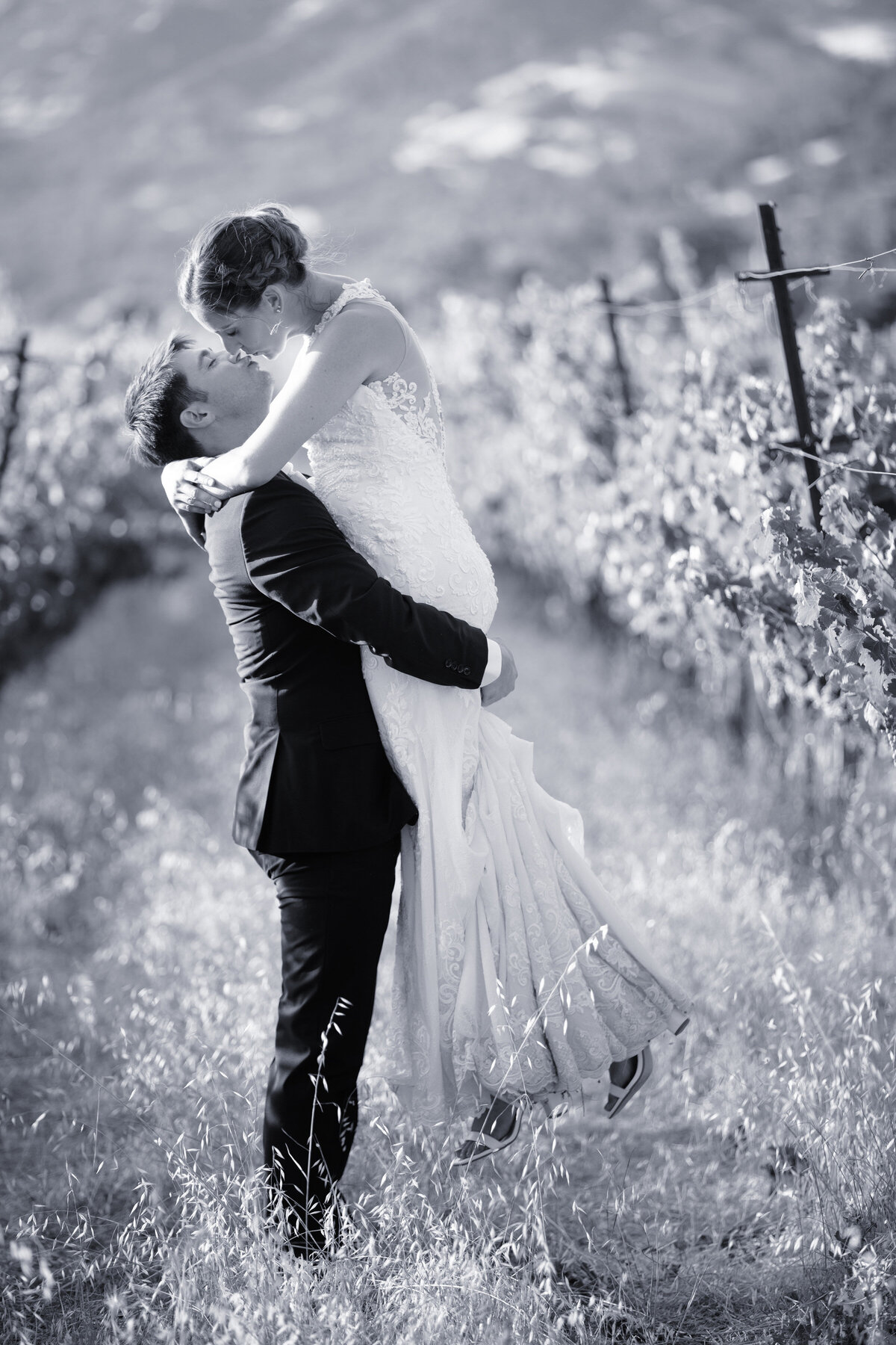 groom lifting bride in grape vines