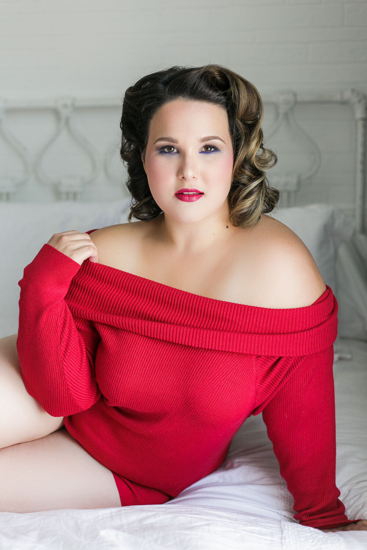 curvy boudoir girl on bed red sweater